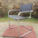 Design armchair with chrome metal tubular base and seat in black Skaï