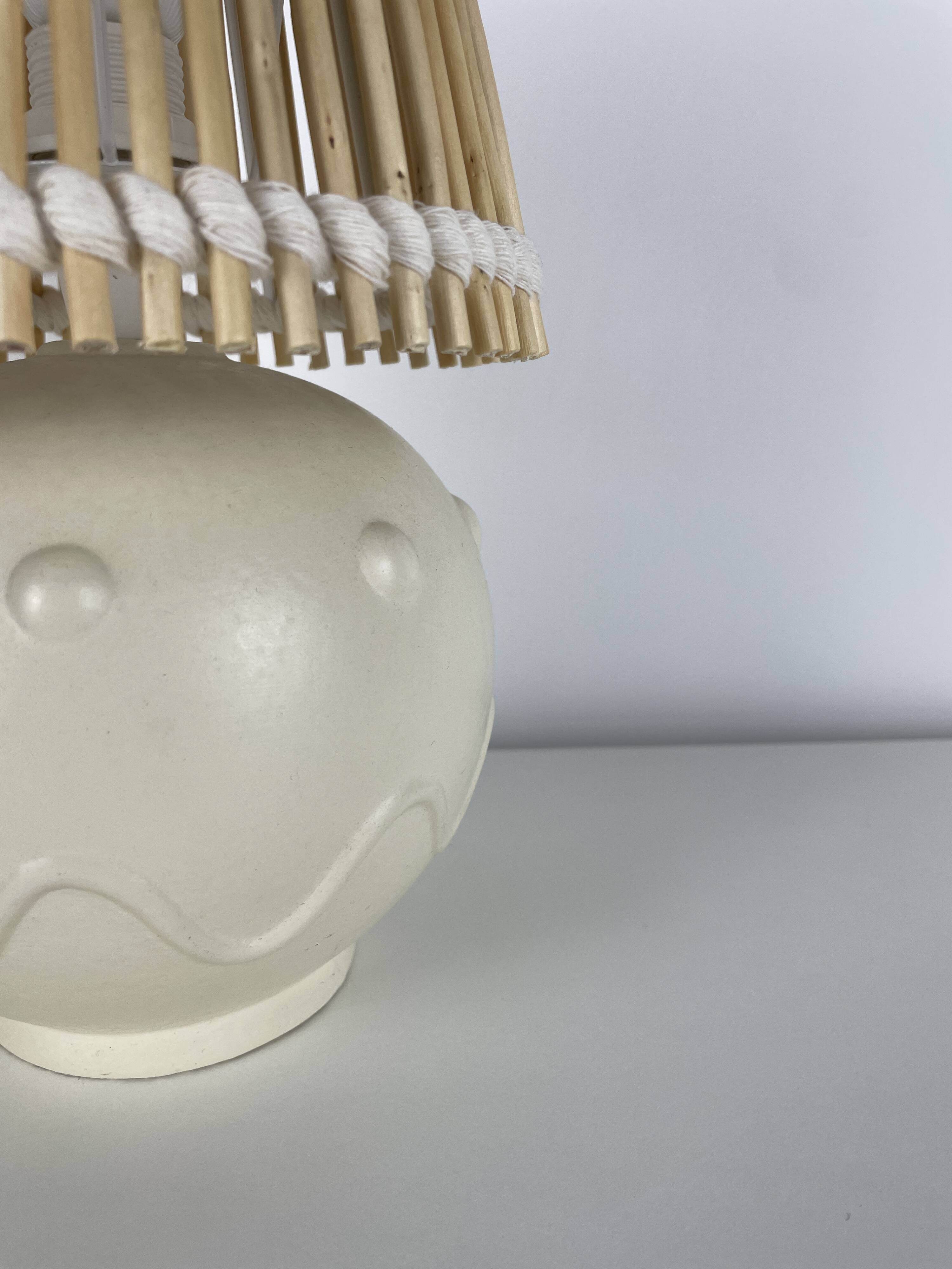 Vintage ceramic lamp with wicker and cotton shade.