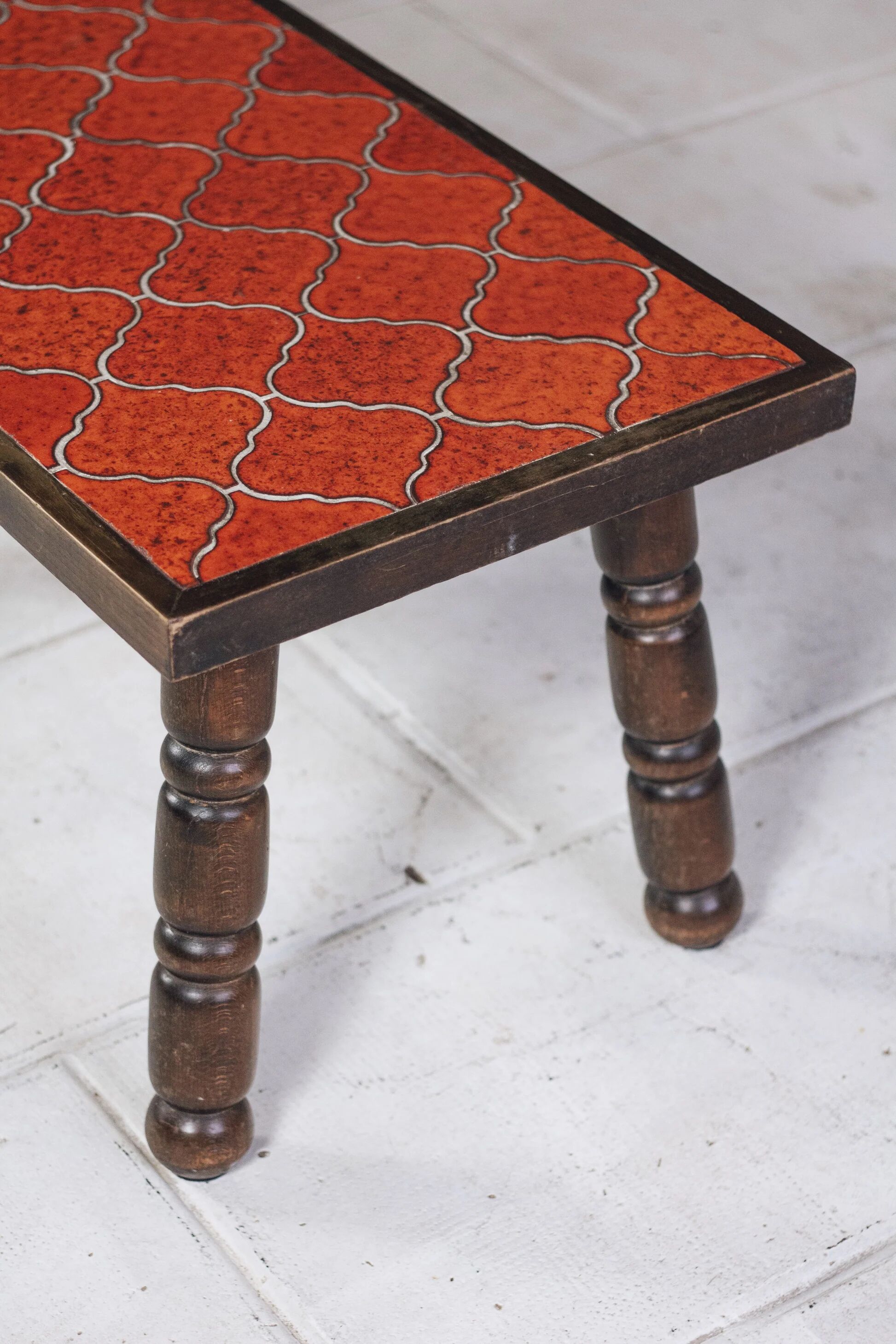 Brutalist coffee table in orange ceramic and solid wood.