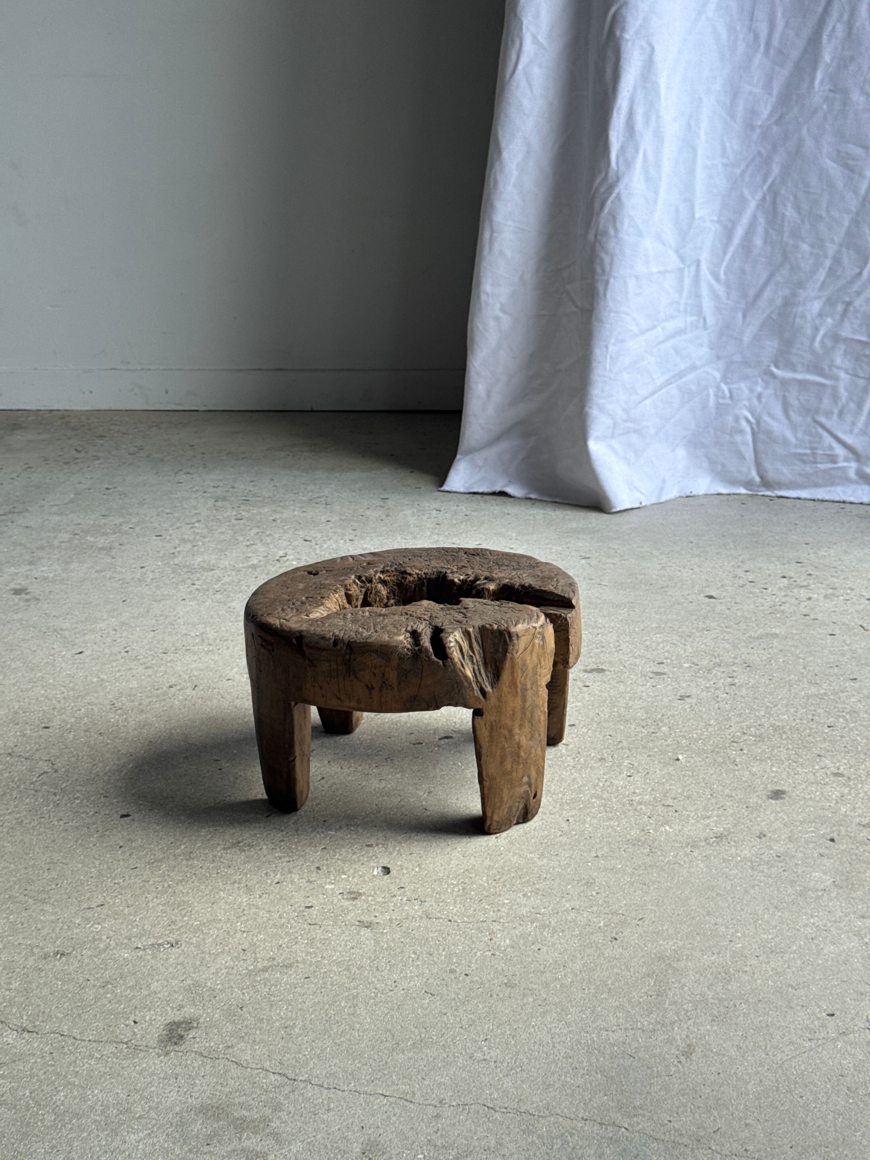 Small low circular four-legged stool in organic old teak with cut-out design H2