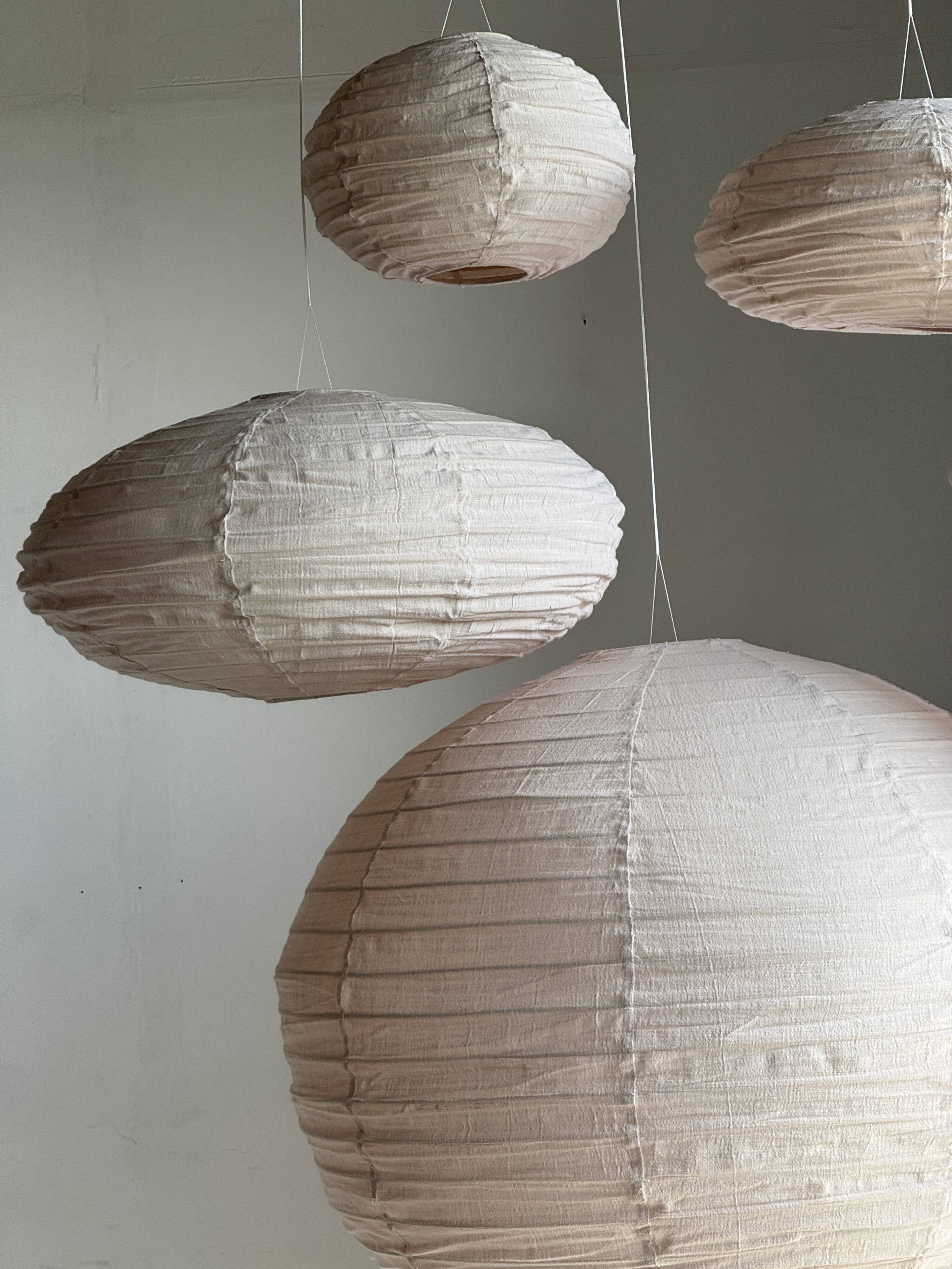Average suspension in natural rattan and linen, Japanese-style, flattened oval in pink.