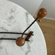 Wall-mounted coat rack in wrought iron with turned wooden knobs.