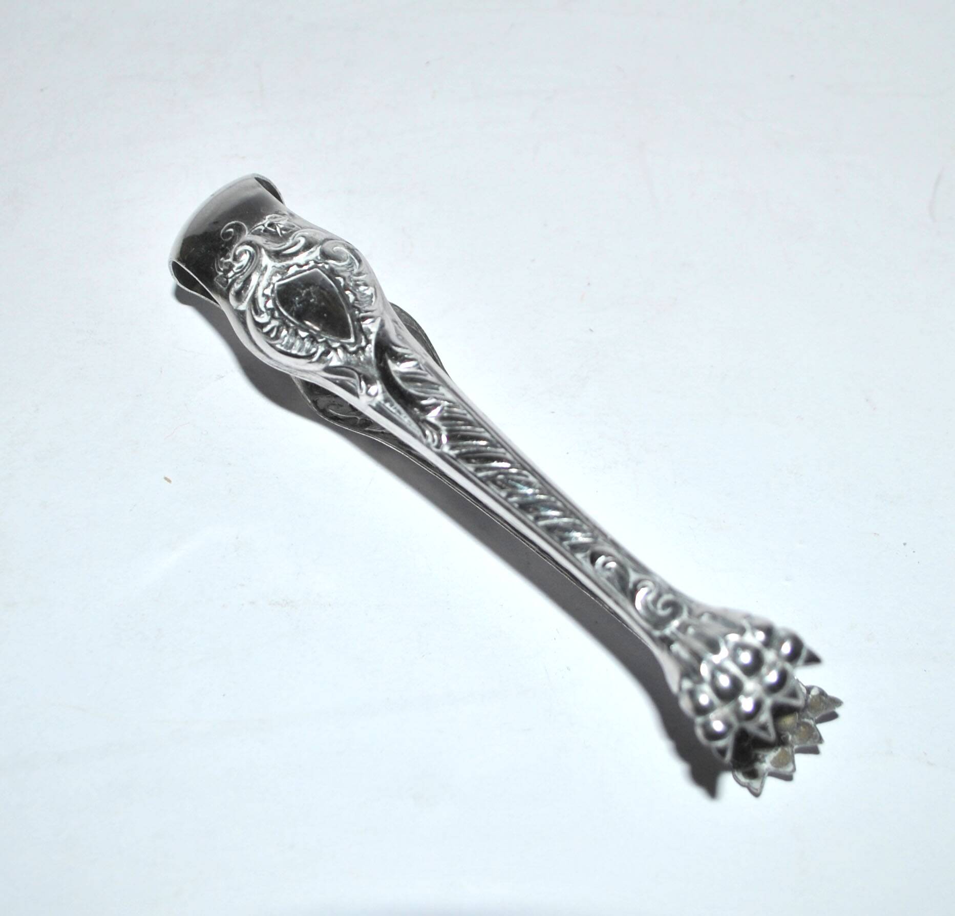 Rocaille sugar tongs in silver metal with lion claw medallion
