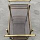 Mid Century Modern bar cart with 2 levels in brass and tinted glass.