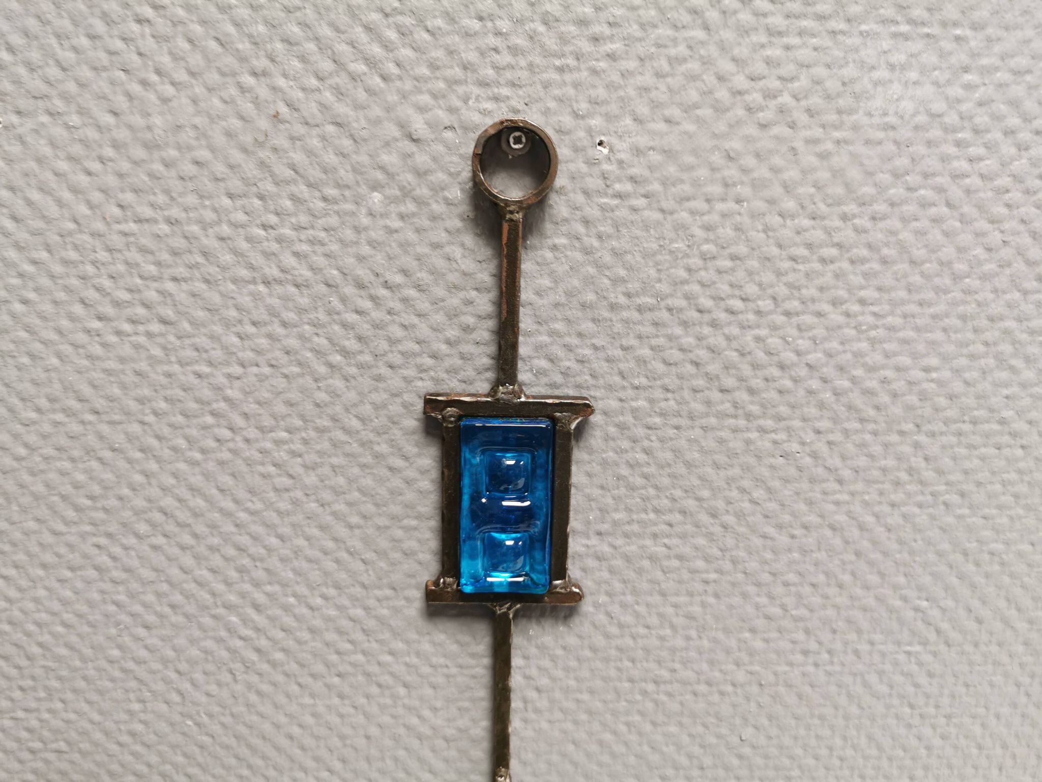 Wall-mounted candle holder in cast iron and hard pressed blue glass.