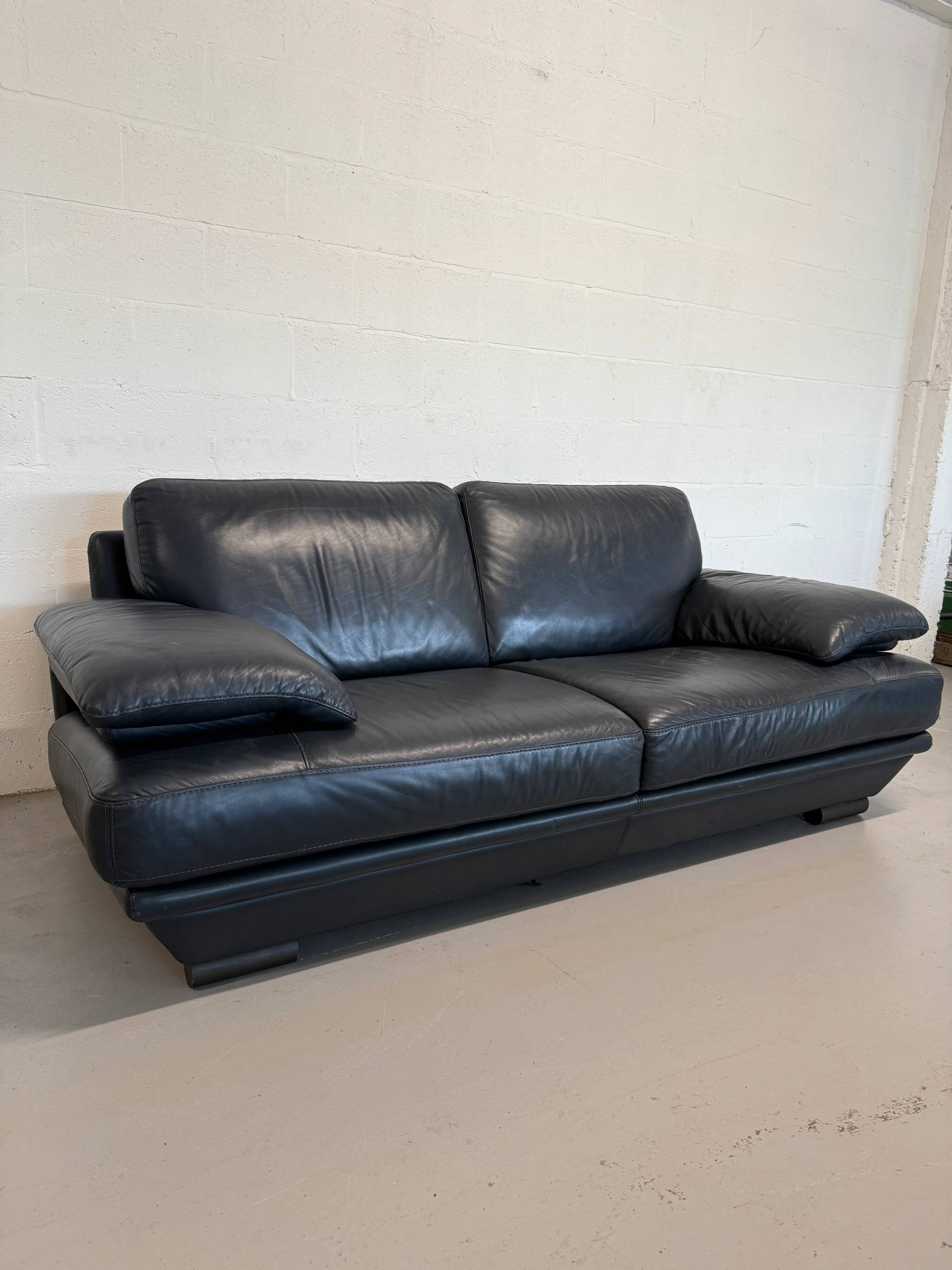Two-seater Natuzzi sofa in navy blue leather.