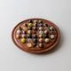 Vintage 1960s solitaire game, wooden board with stone marbles.