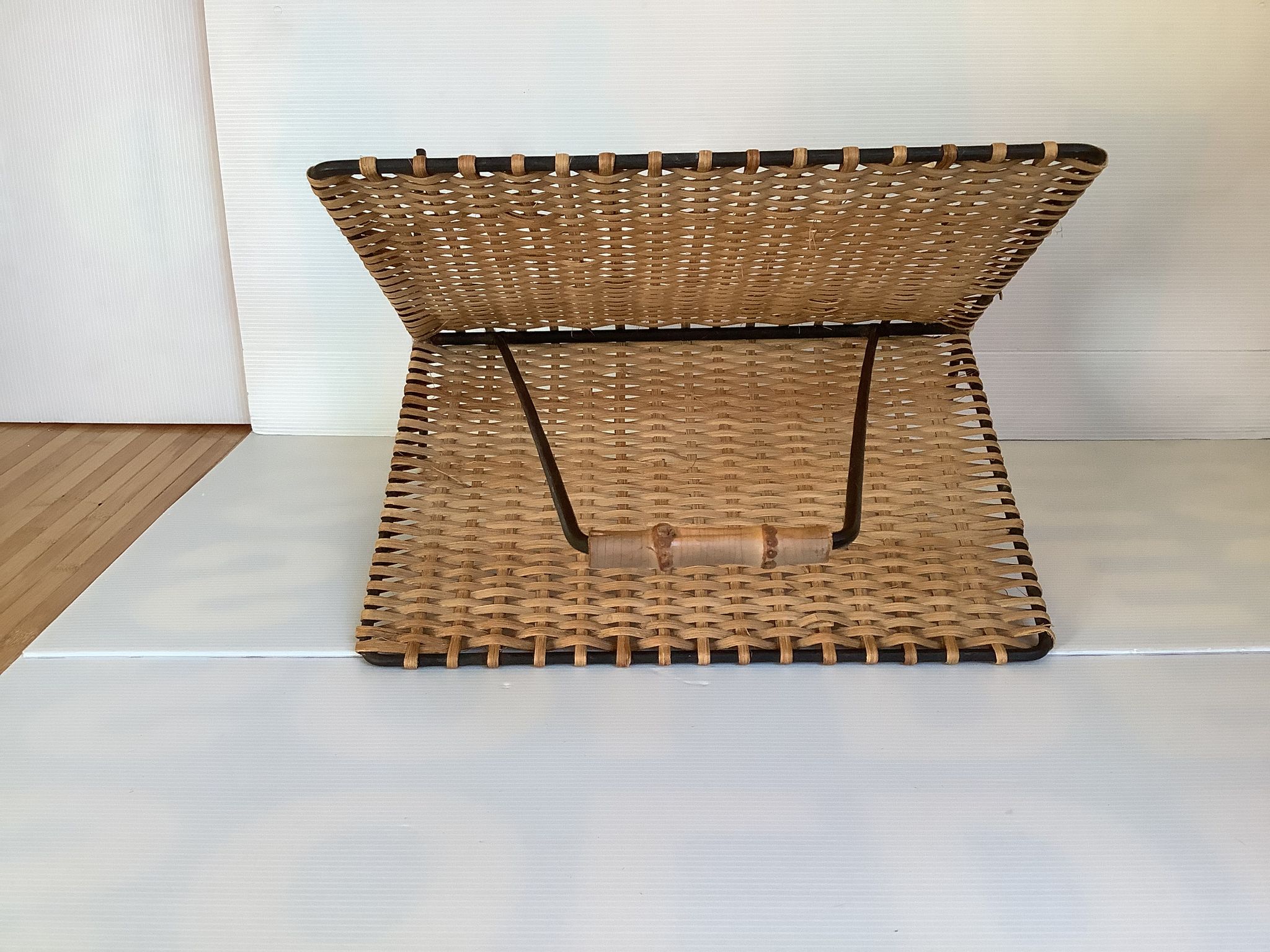 Old magazine rack in straw and black metal
