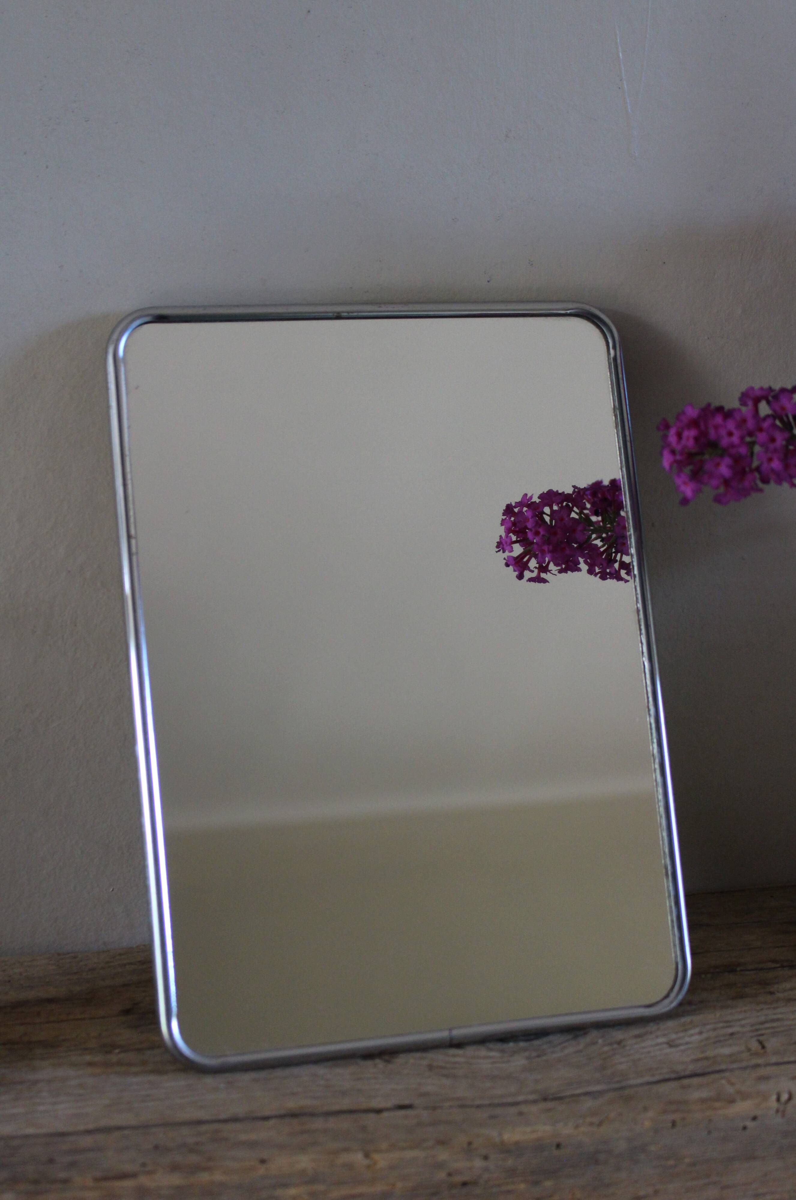 Simple rectangular barber mirror with a stand.