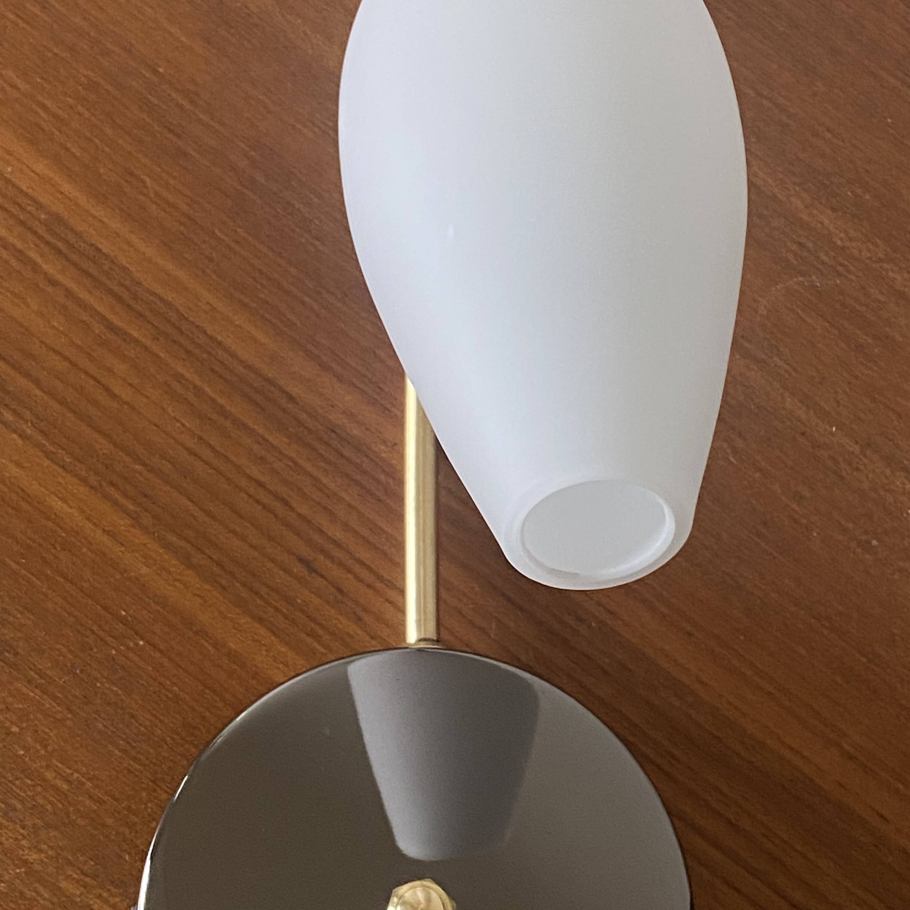Swan neck wall light in brass and white opaline glass tulip.