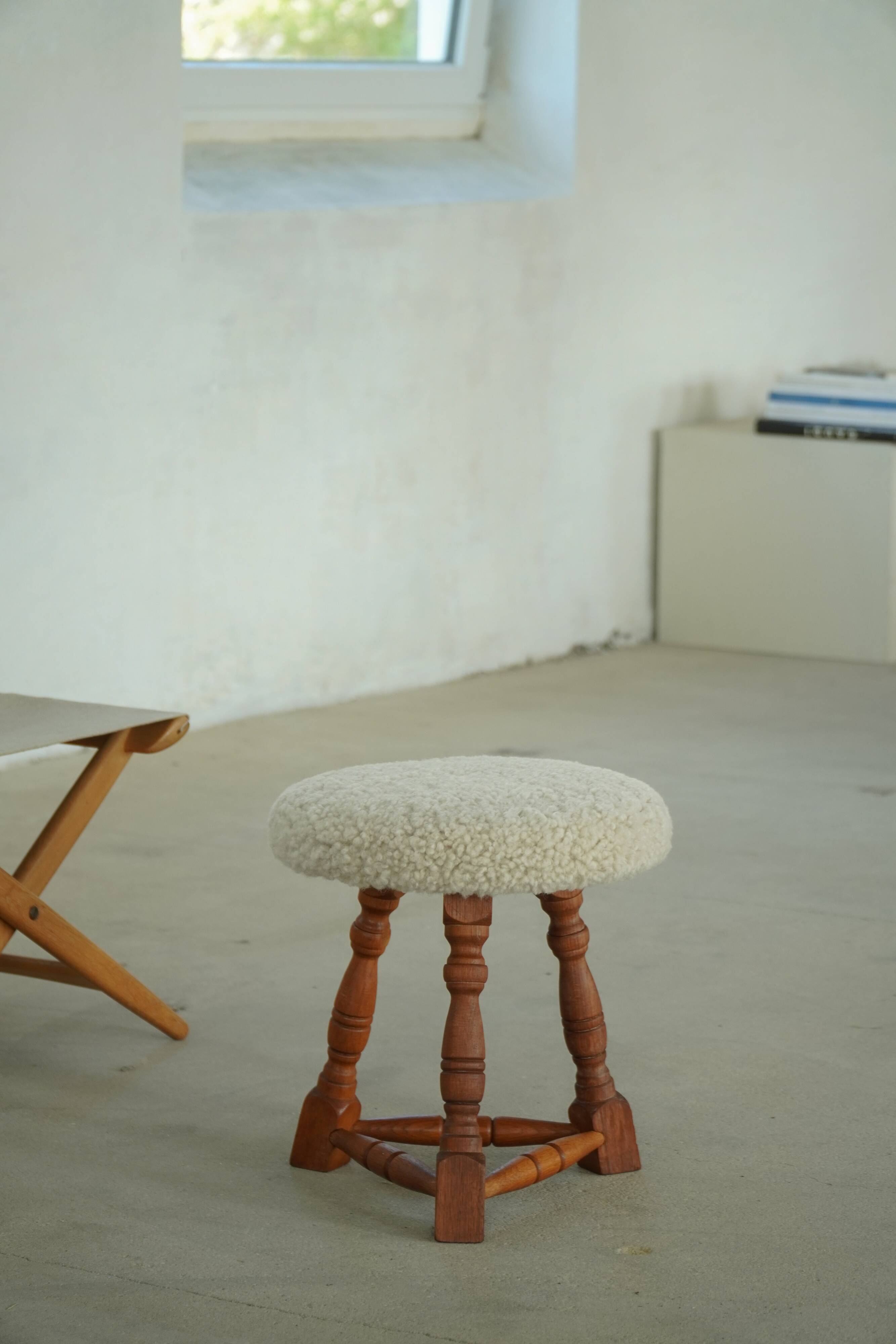 Modern Danish stool, with three oak legs featuring turned feet and a lambswool seat, 1950s.