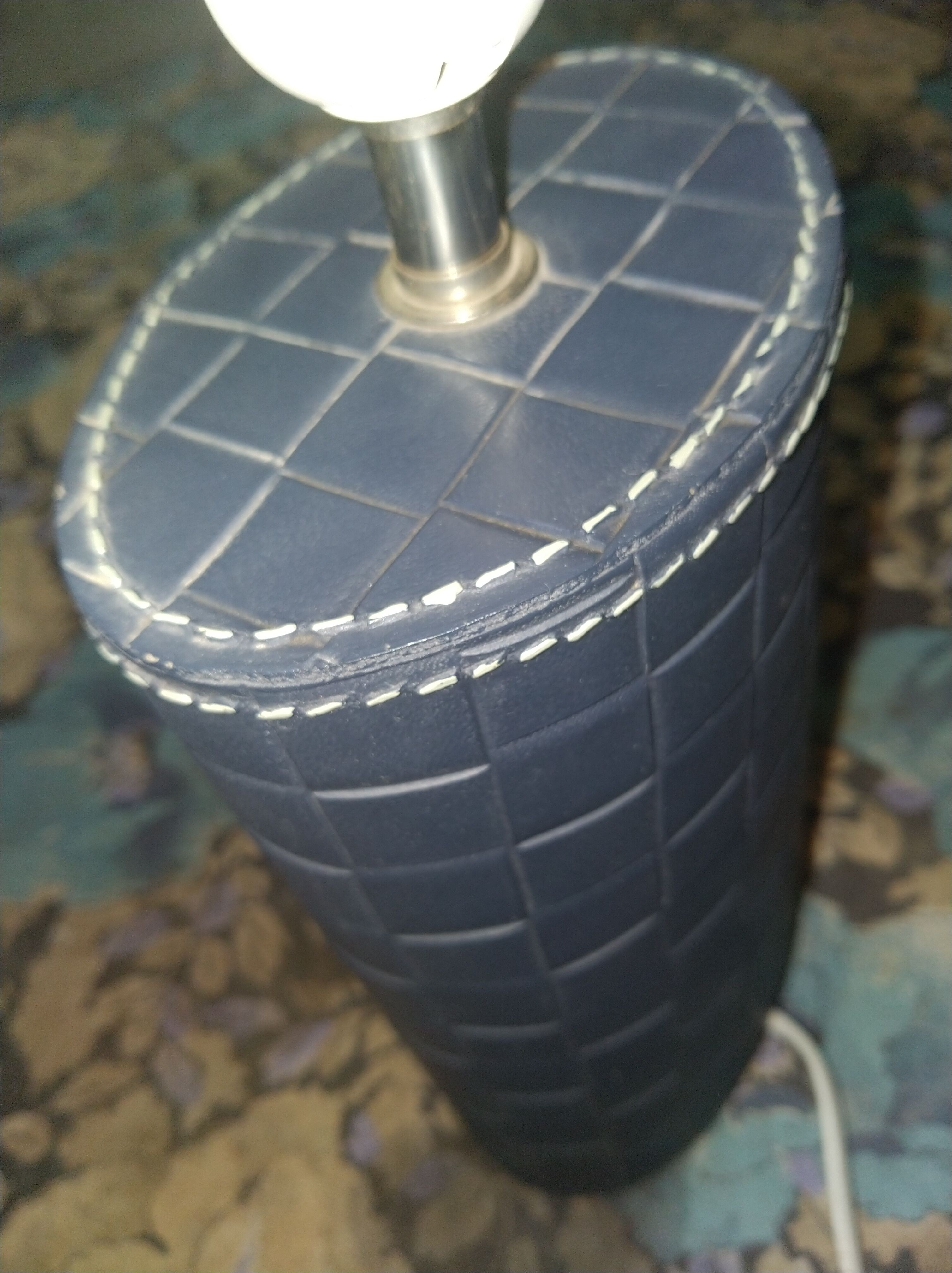 Ovoid lamp sheathed in braided blue leather and saddle stitching