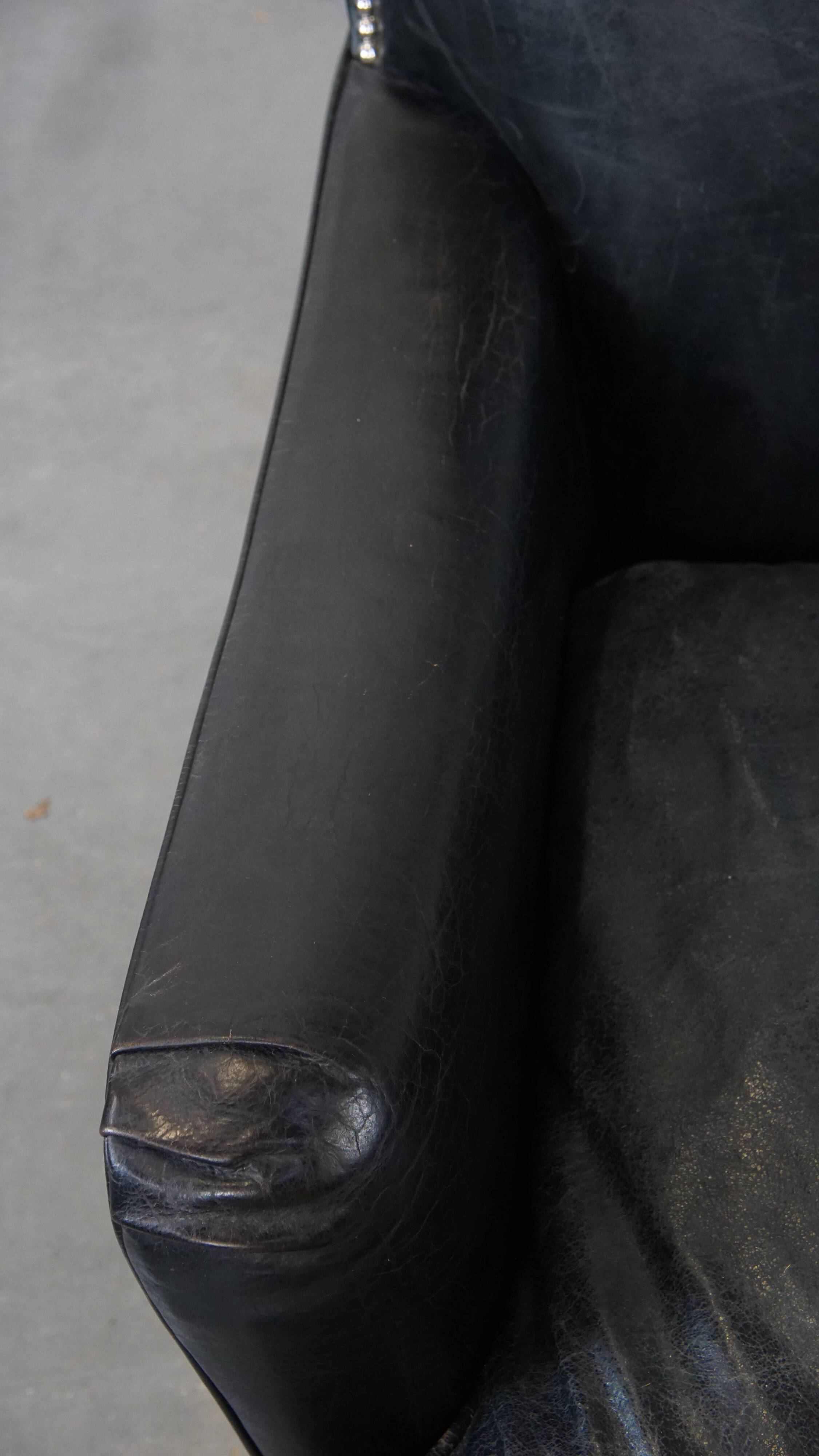 Armchair in black grained cowhide leather with a deep seat