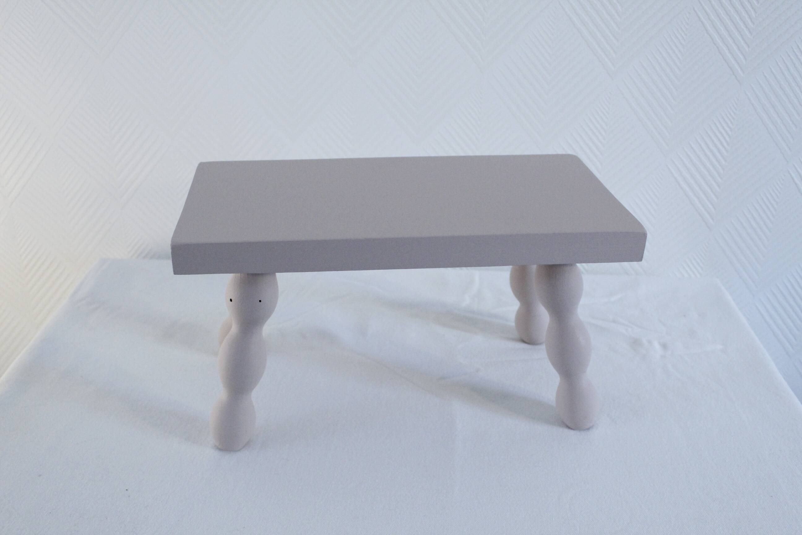 Small vintage wooden bench renovated in pinkish beige
