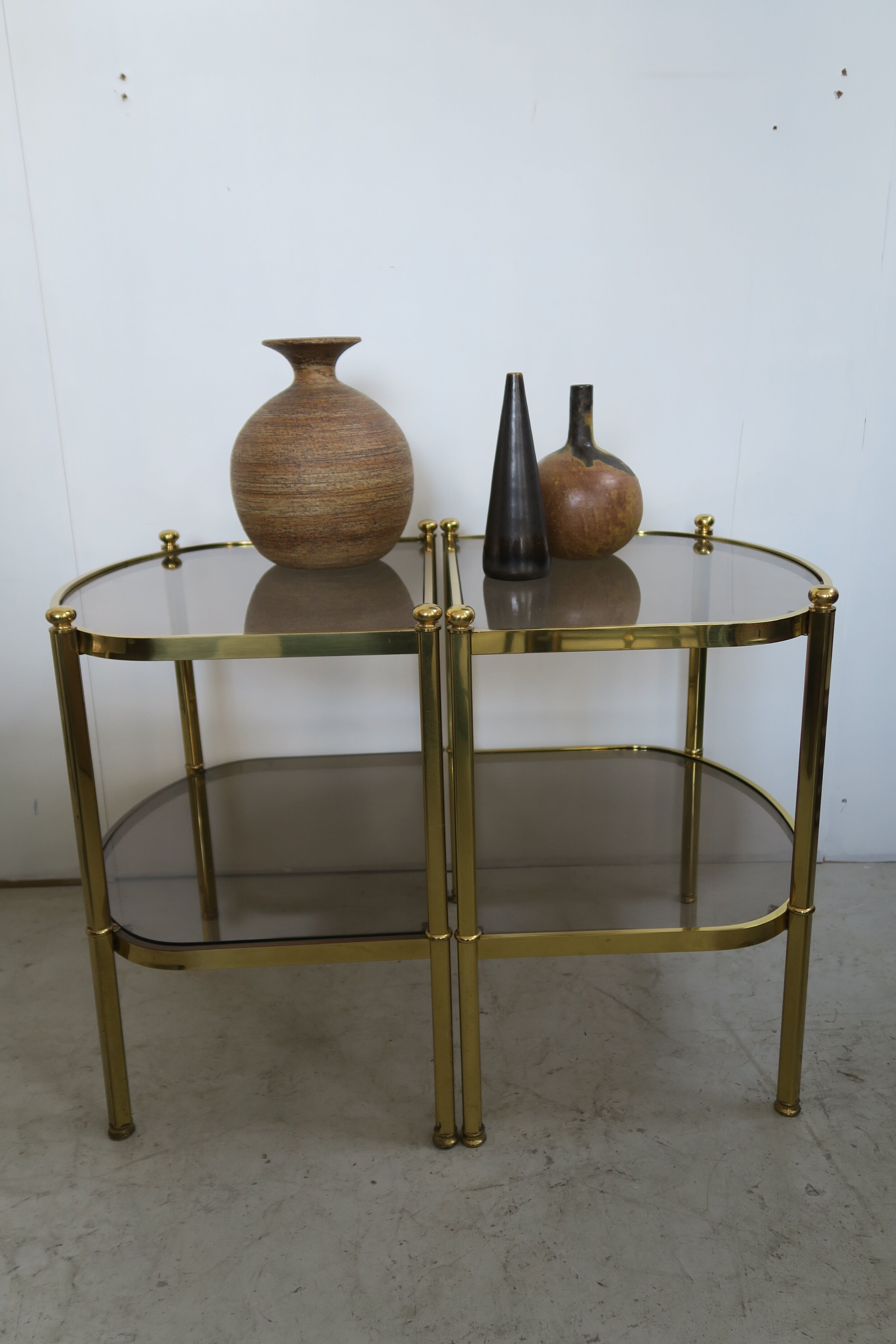 Paire de tables d’appoint en laiton et verre fumant des années 70