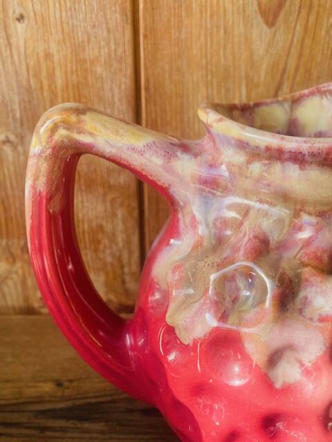 Old pitcher in burgundy ceramic