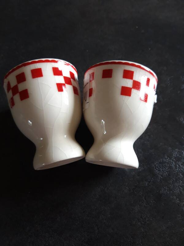 2 white egg cups with red tiles