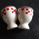 2 white egg cups with red tiles