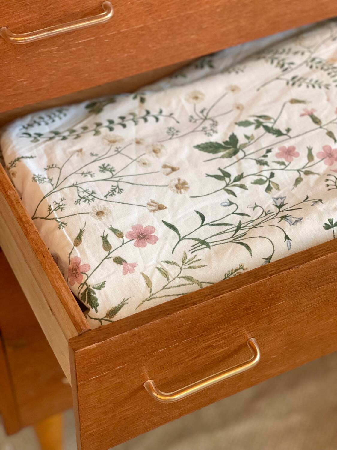 Vintage 1960s chest of drawers with covered handles.