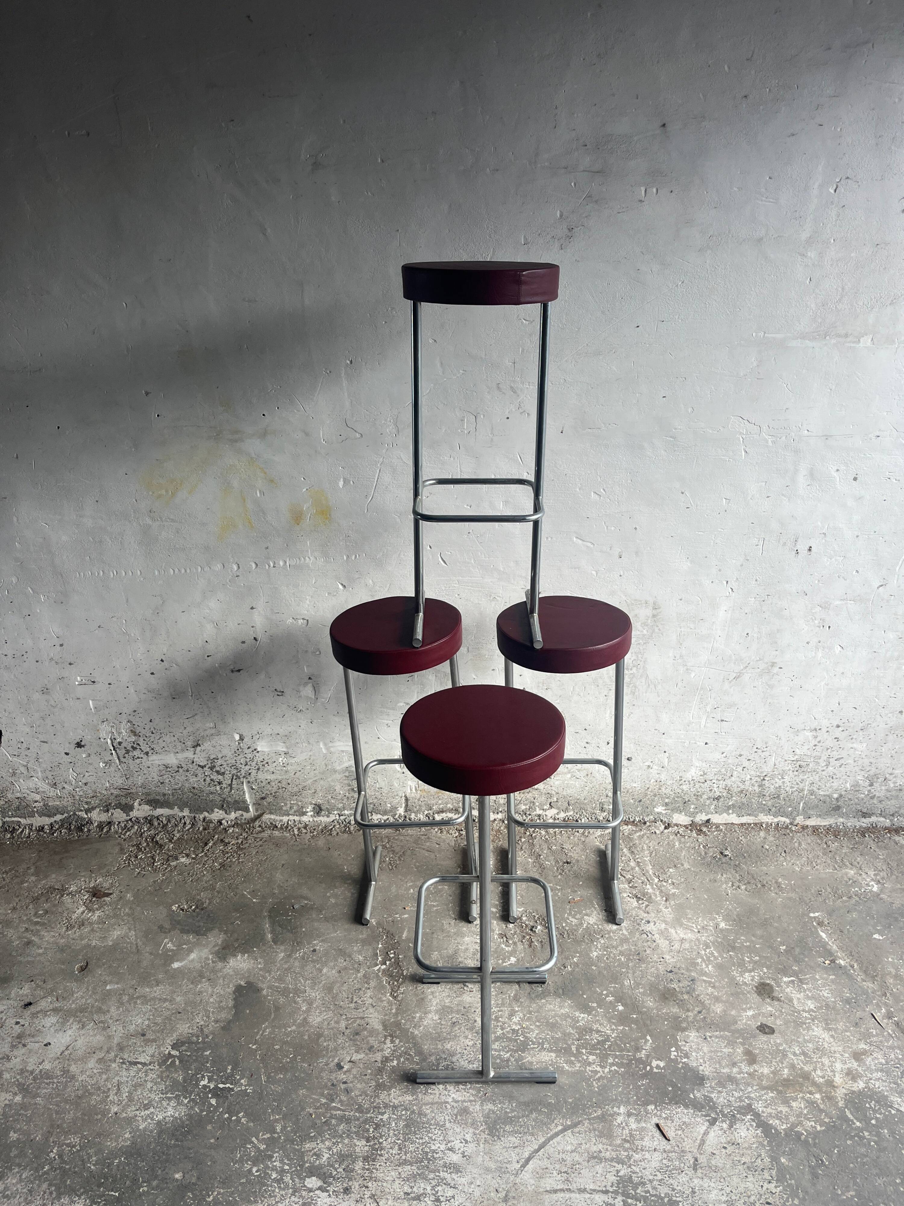 Ensemble de 4 tabourets de bar industriels – sièges bordeaux (années 1980)
