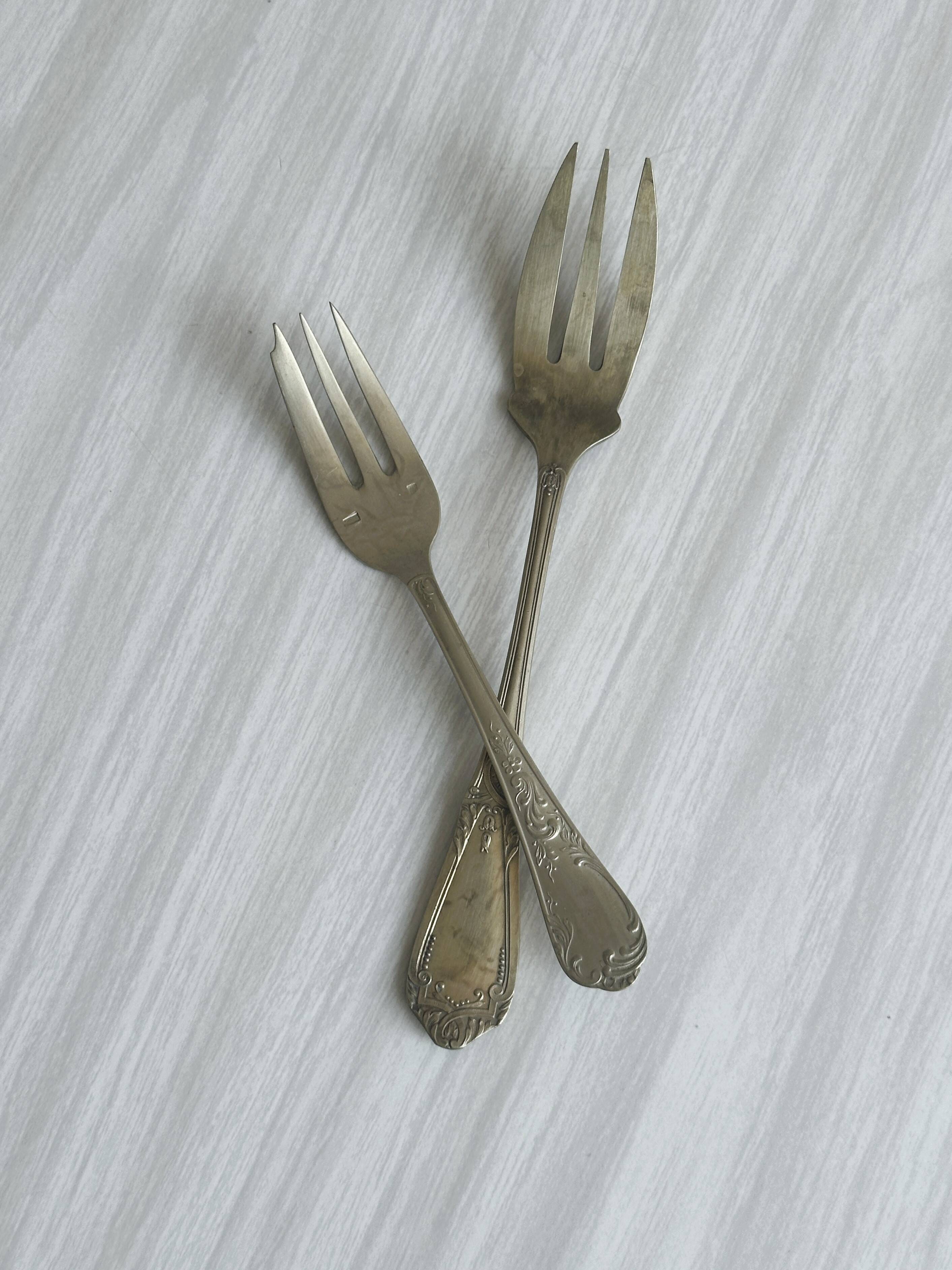 Paire de fourchettes en métal argenté, design orné