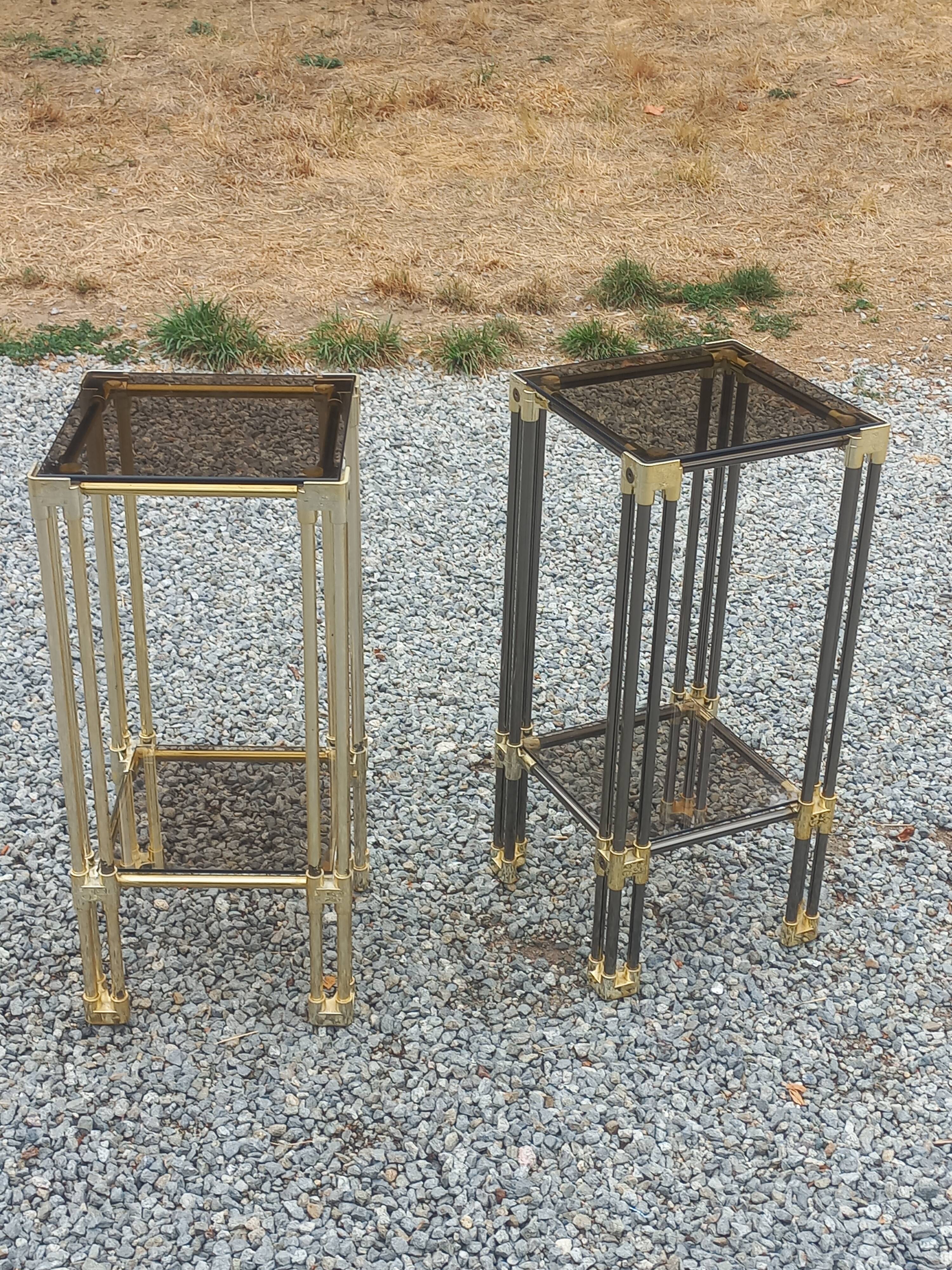 Pair of Hollywood Regency side tables in gold metal and smoked glass.