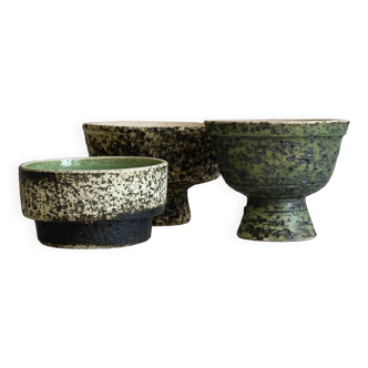 Three cups, textured ceramic bowls in different colors.