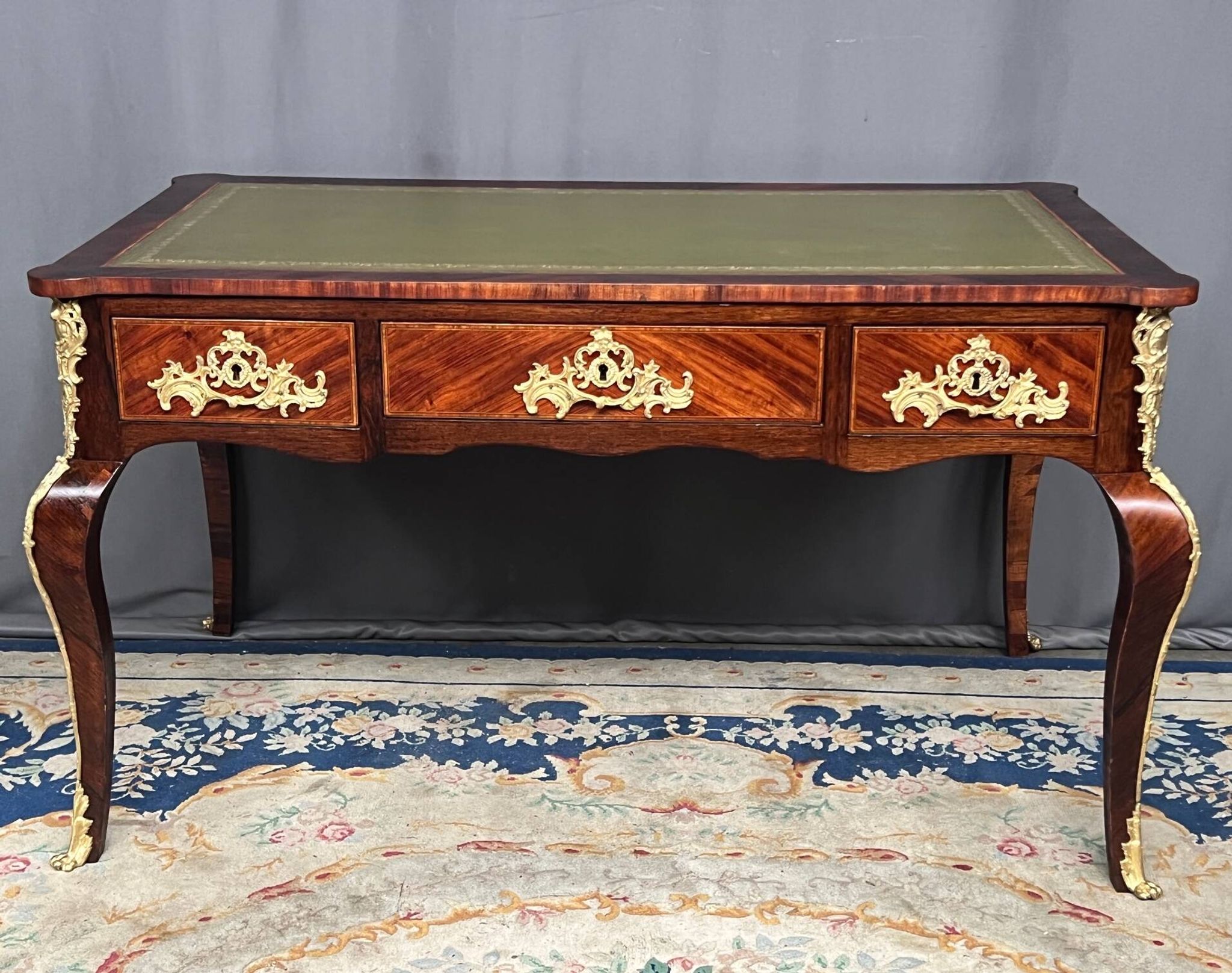Louis XV style desk. Rosewood veneer, gilt bronze decoration, leather.