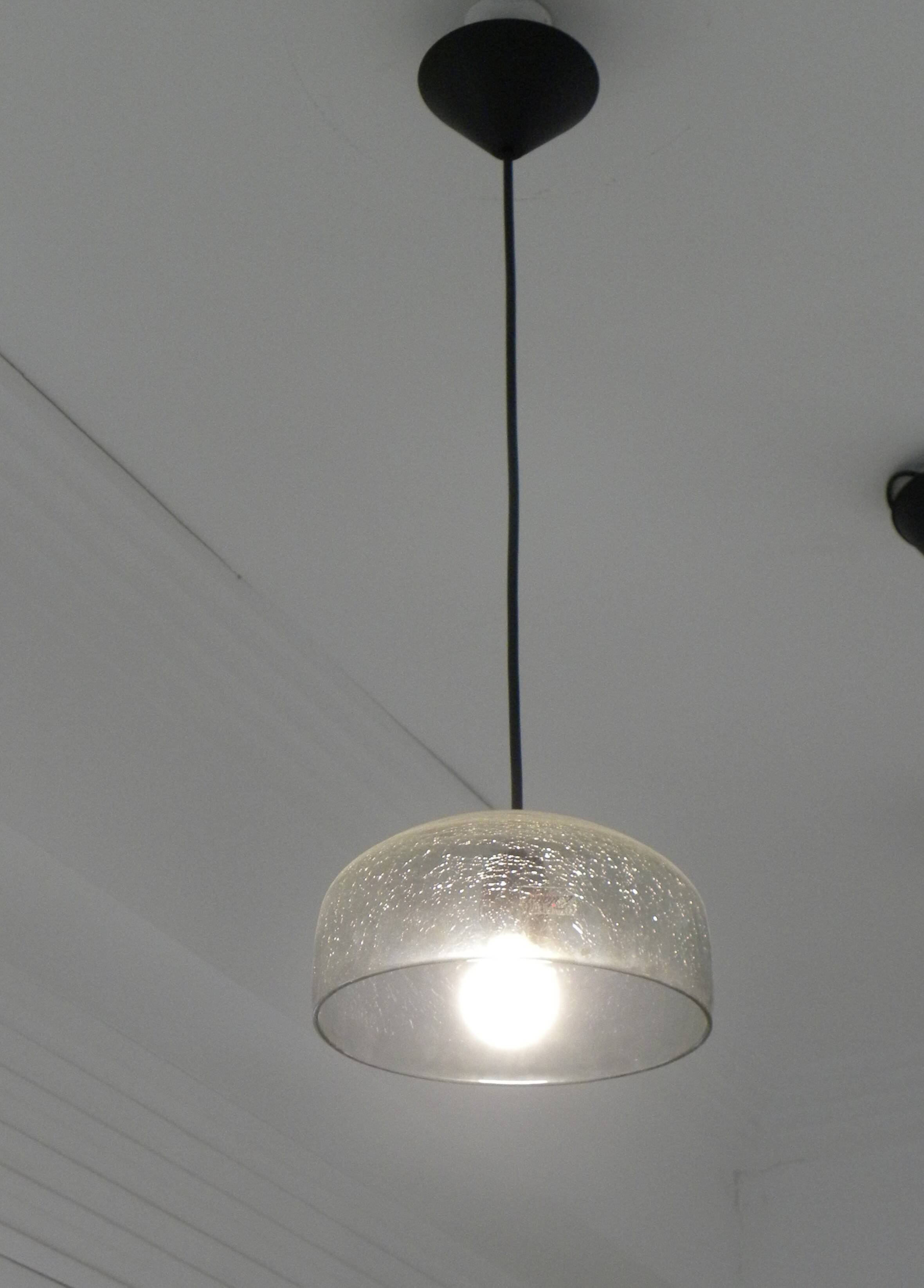 Modern suspended lamp in cracked blown glass, minimalist design.