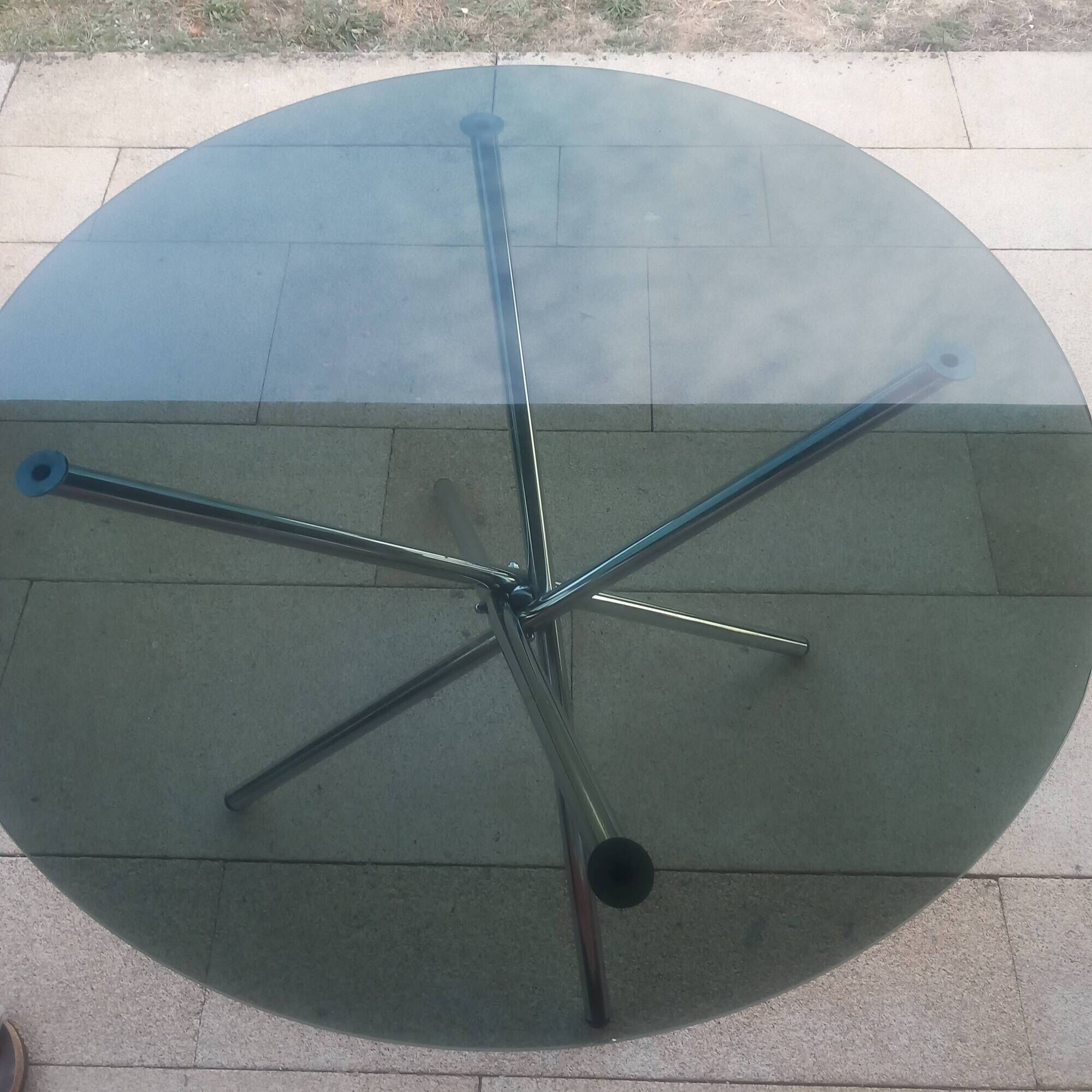 Round smoked glass table from the 70s. Foldable stainless steel legs.