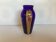 Ancient blue and gold glass vase with a floral pattern.