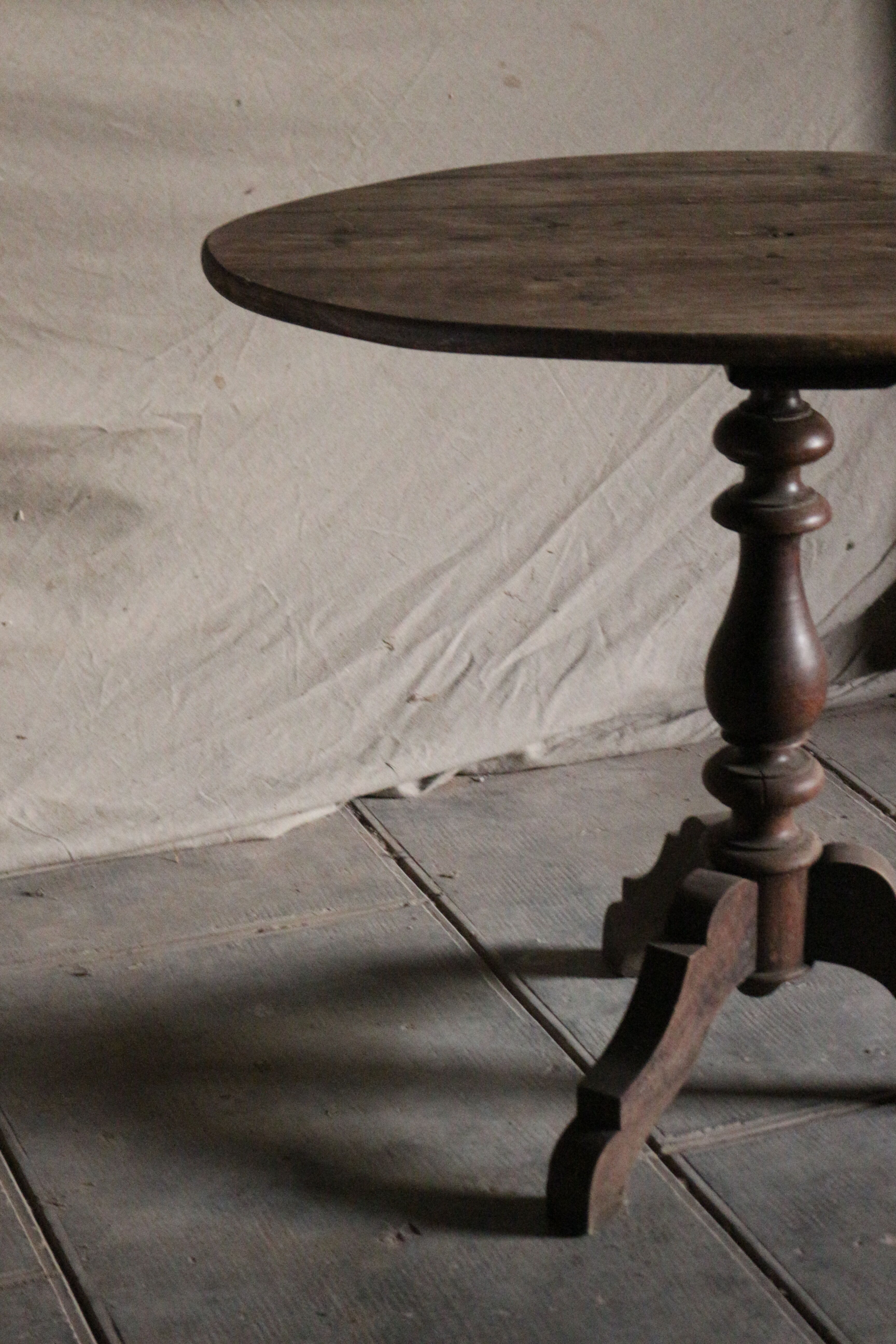 Old oval pedestal table in raw wood