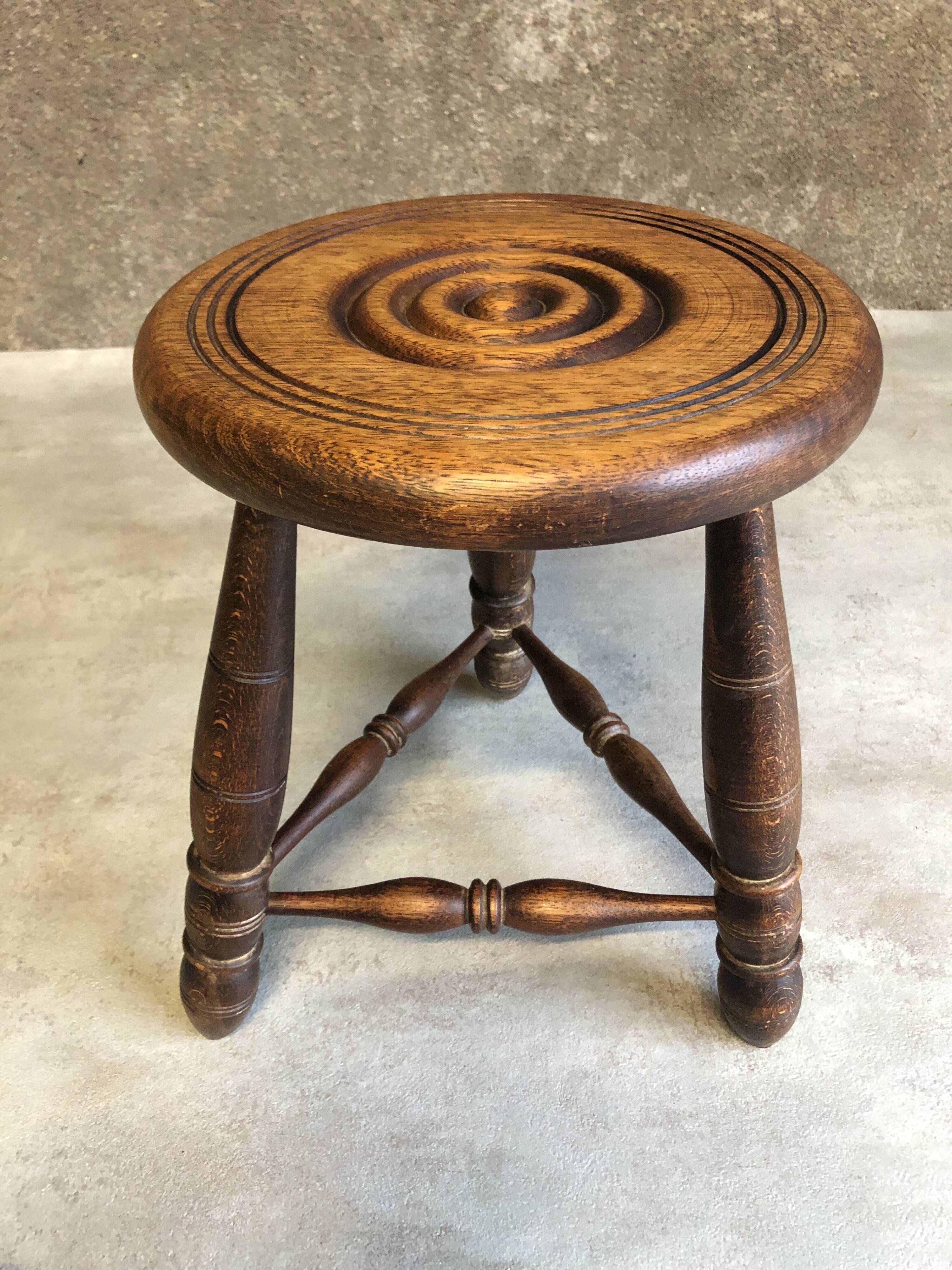 Round tripod stool in dark wood