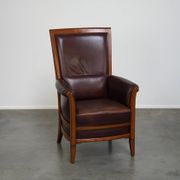 Very comfortable classic cowhide armchair with a high back in a mild Art Deco style