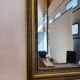 Vintage rectangular wall mirror with a golden wooden frame.
