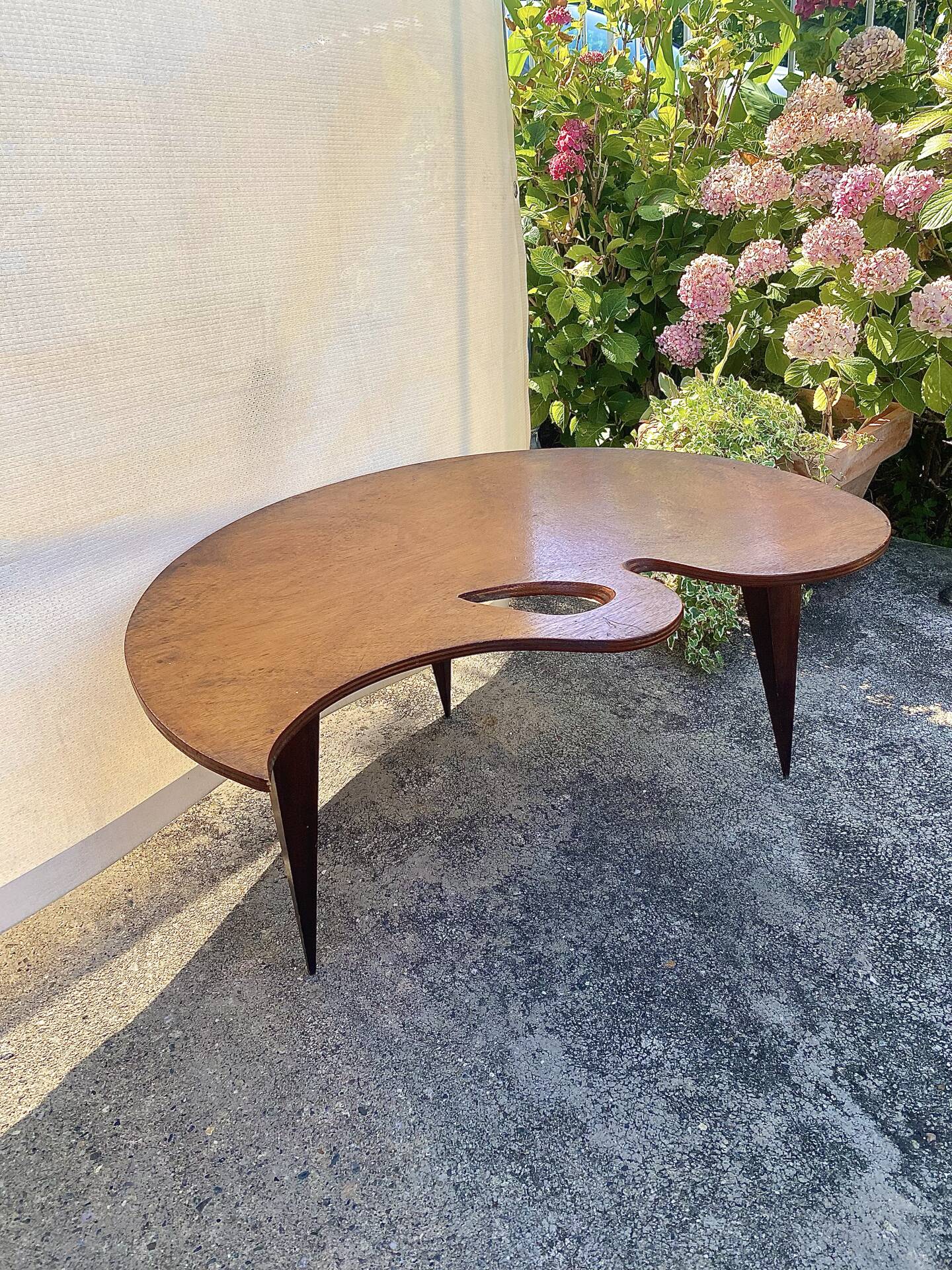 Mid-century coffee table with a palette shape and splayed legs.