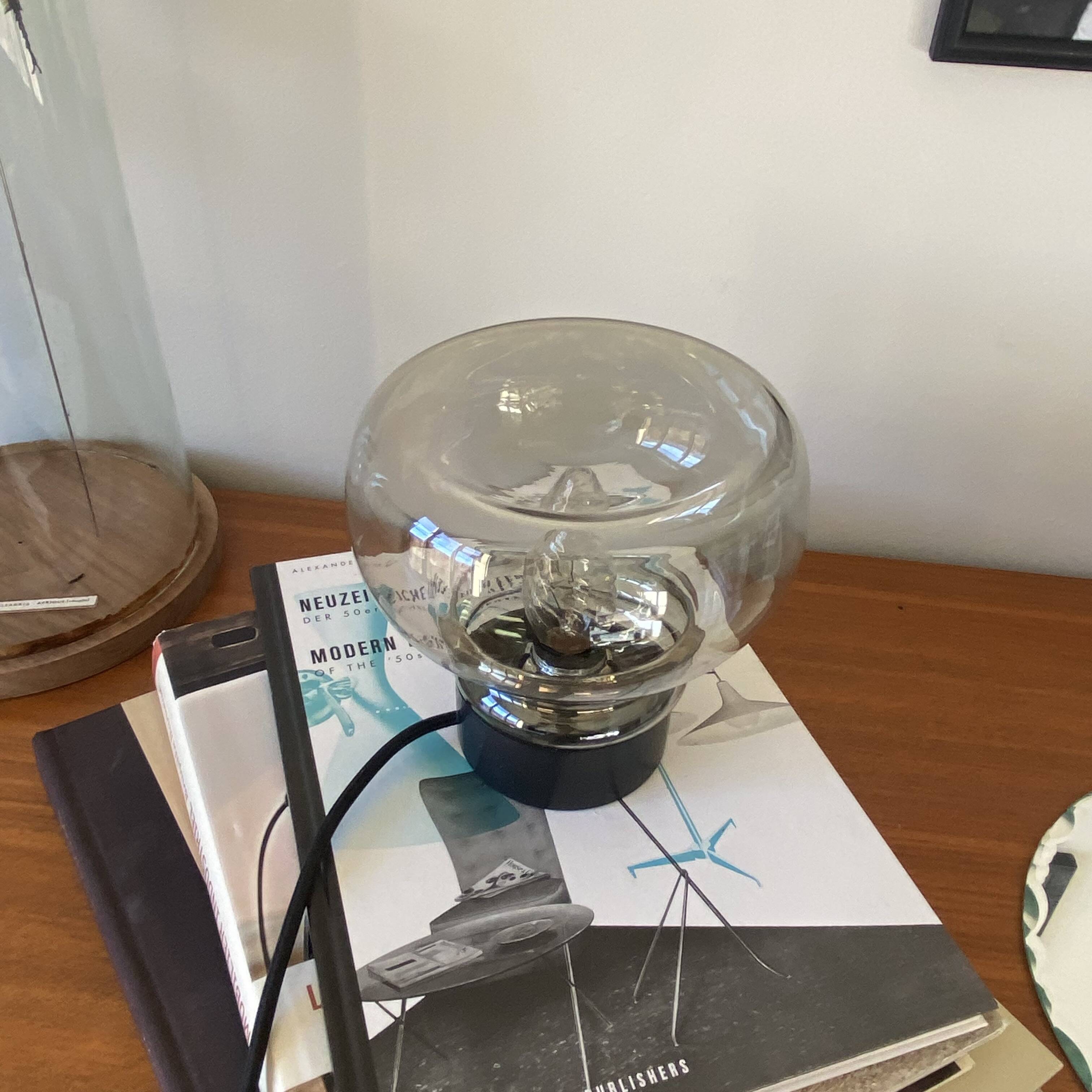 Sciolari table lamp with smoked glass globe and black plastic base.