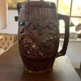 Hungarian folk ceramic pitcher with a brown glossy finish and relief decoration of vine.