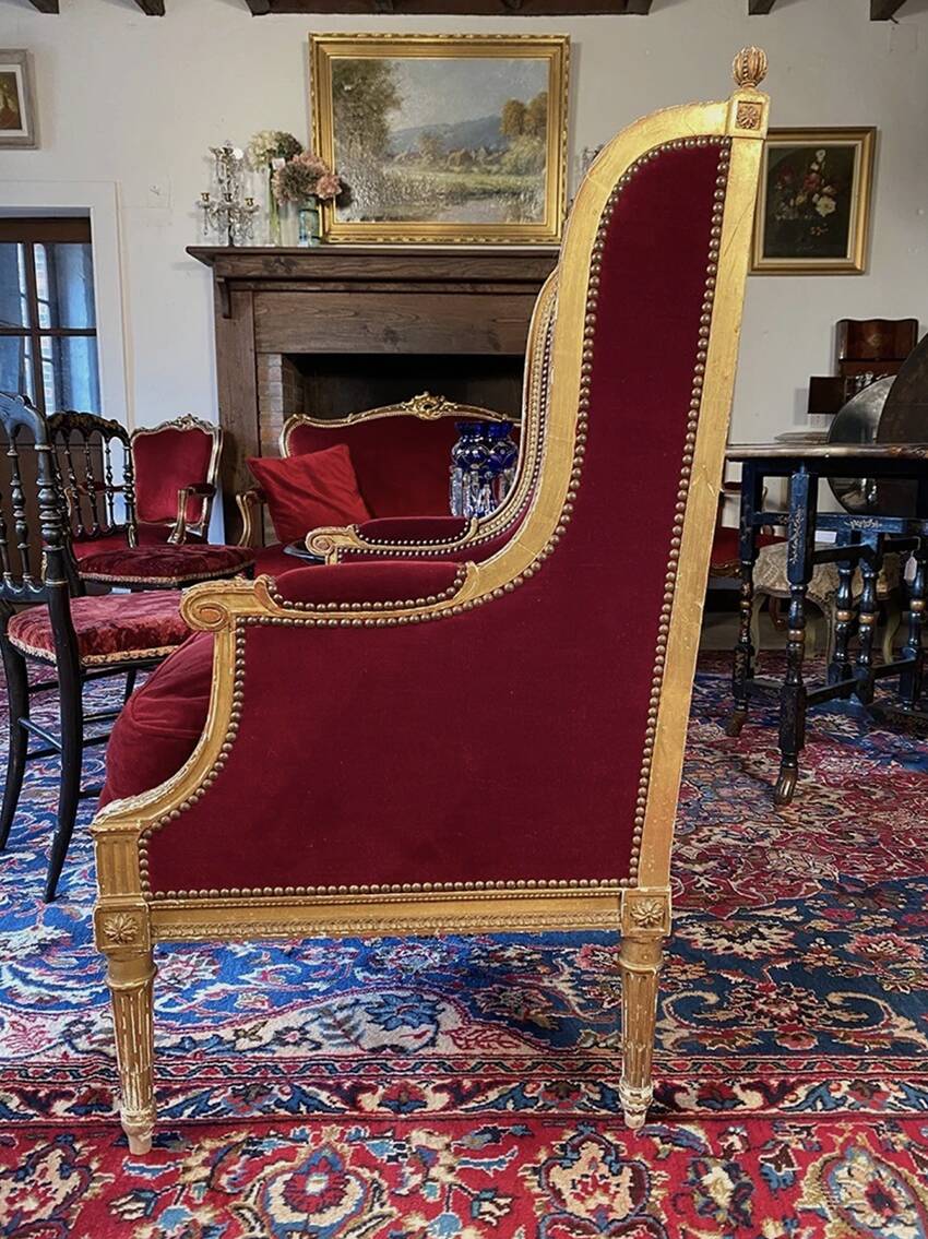 Golden wooden bergère in Louis XVI style upholstered in Bordeaux velvet.