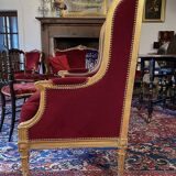 Golden wooden bergère in Louis XVI style upholstered in Bordeaux velvet.