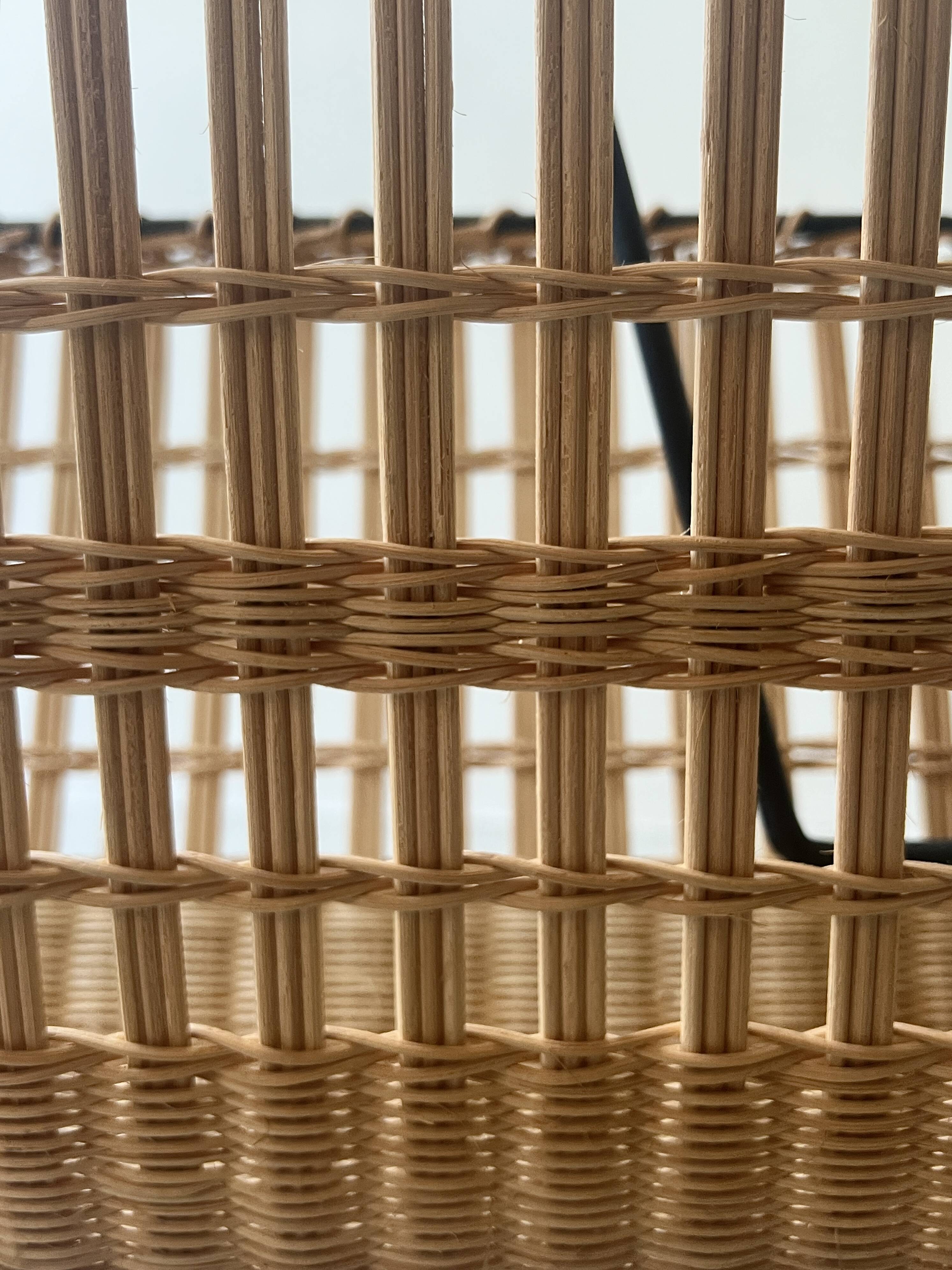 Black metal and rattan magazine rack by Raoul Guys, 1950.