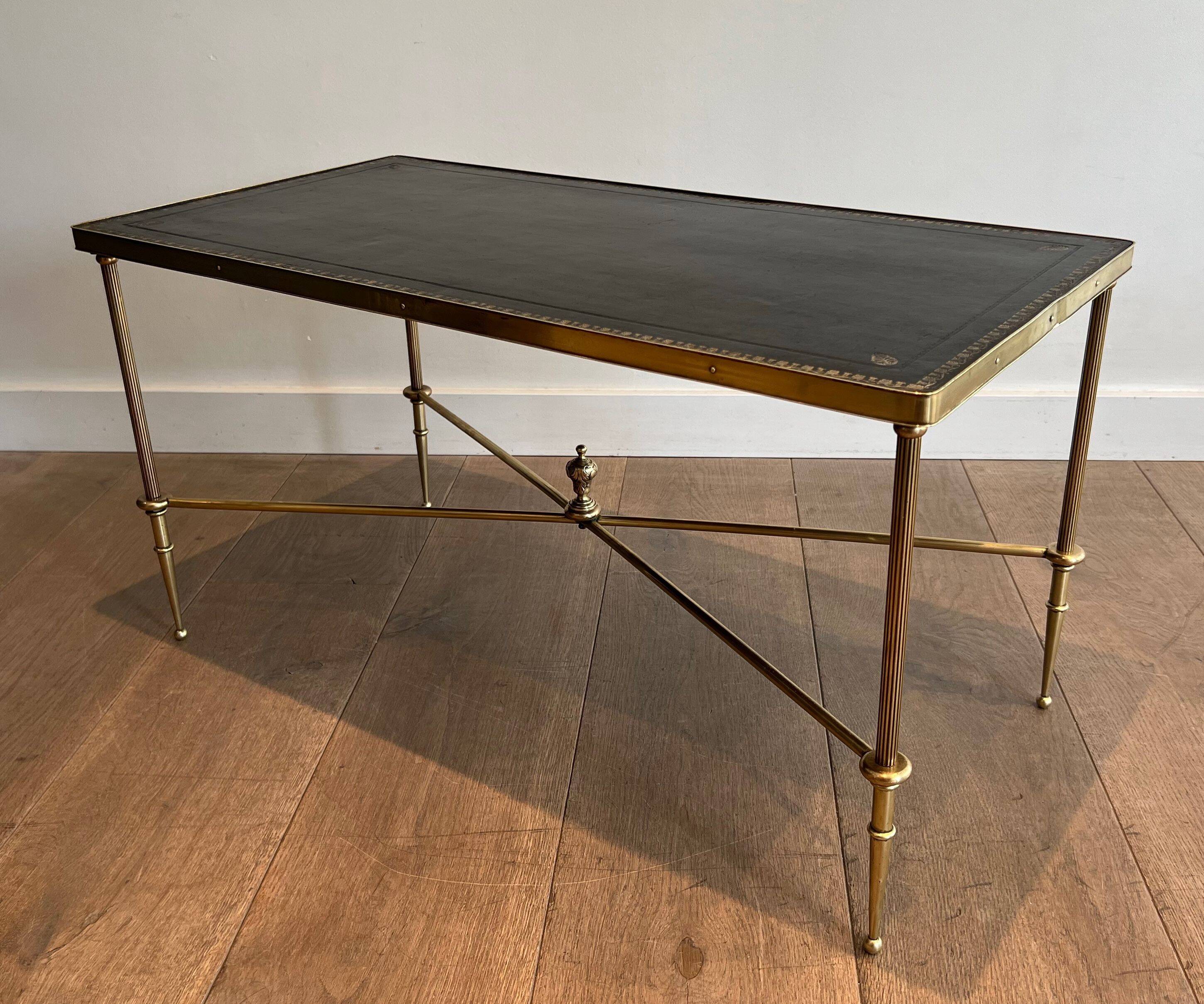 Neoclassical brass coffee table with a black leather top and golden borders from Maison Jansen.