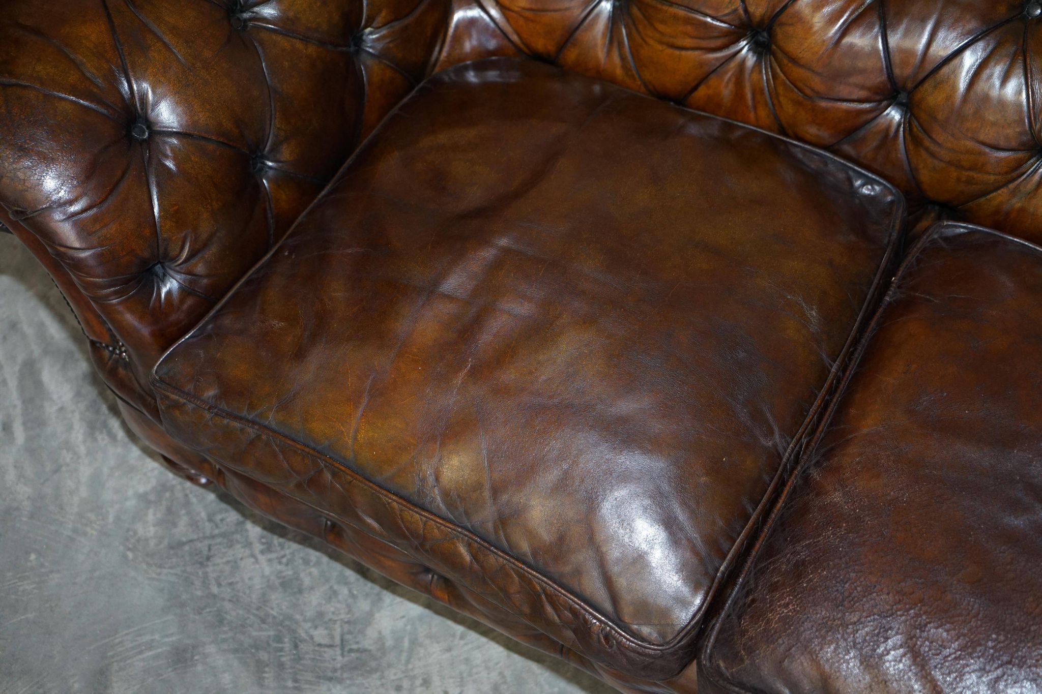 Victorian Chesterfield leather upholstered canapé with feather cushions.