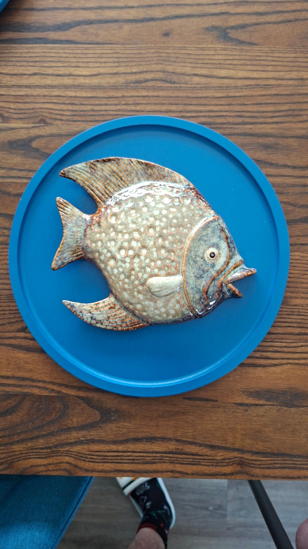 Vallauris ceramic wall sculpture of a relief fish on a blue plaque.