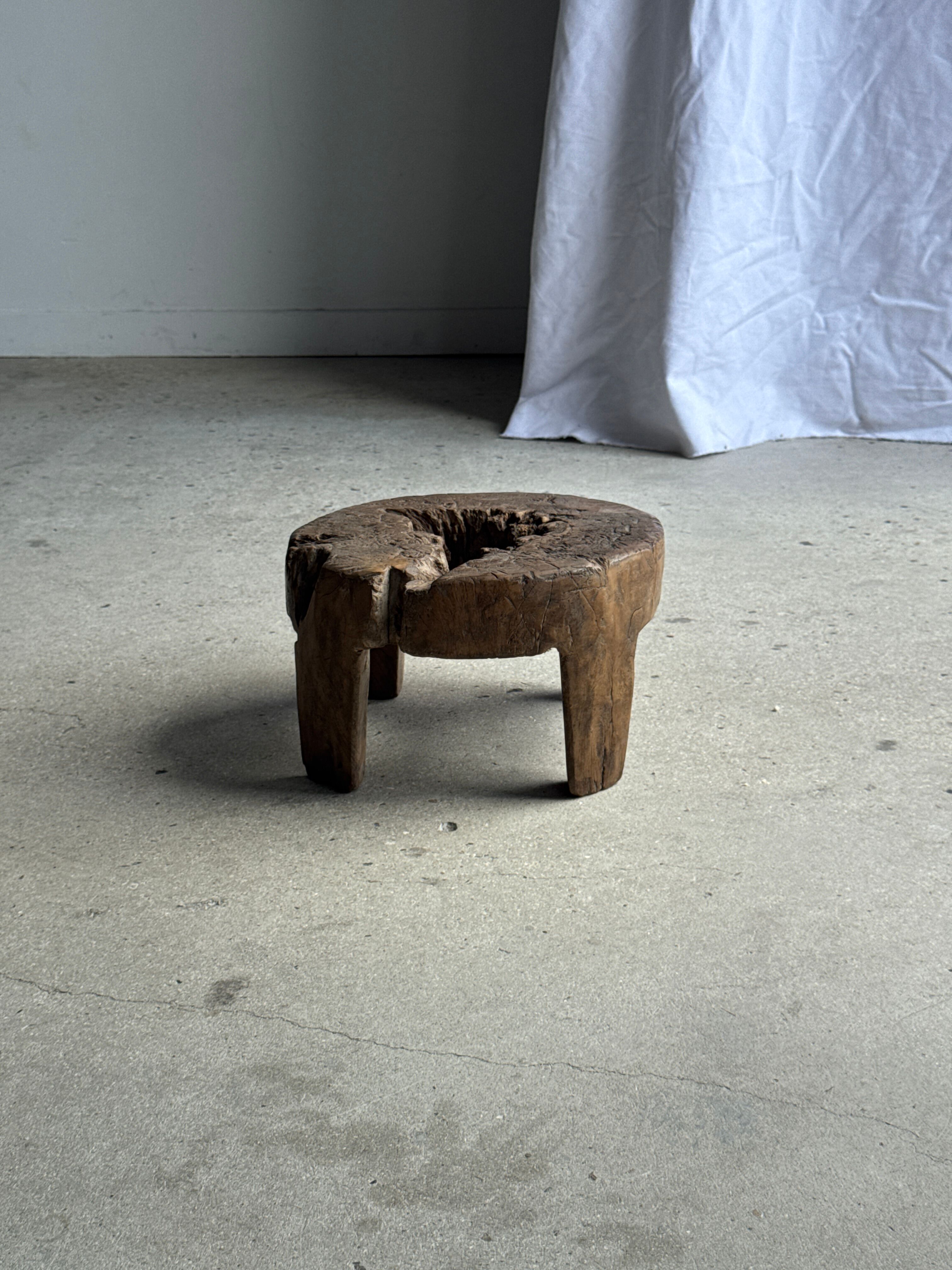 Small low circular four-legged stool in organic old teak with cut-out design H2
