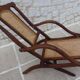 Antique folding chair with caned seat and backrest made of wood.