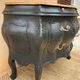 Curved commode painted in black and wood.