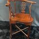 Corner armchair in solid wood with carved floral decoration featuring a bird.