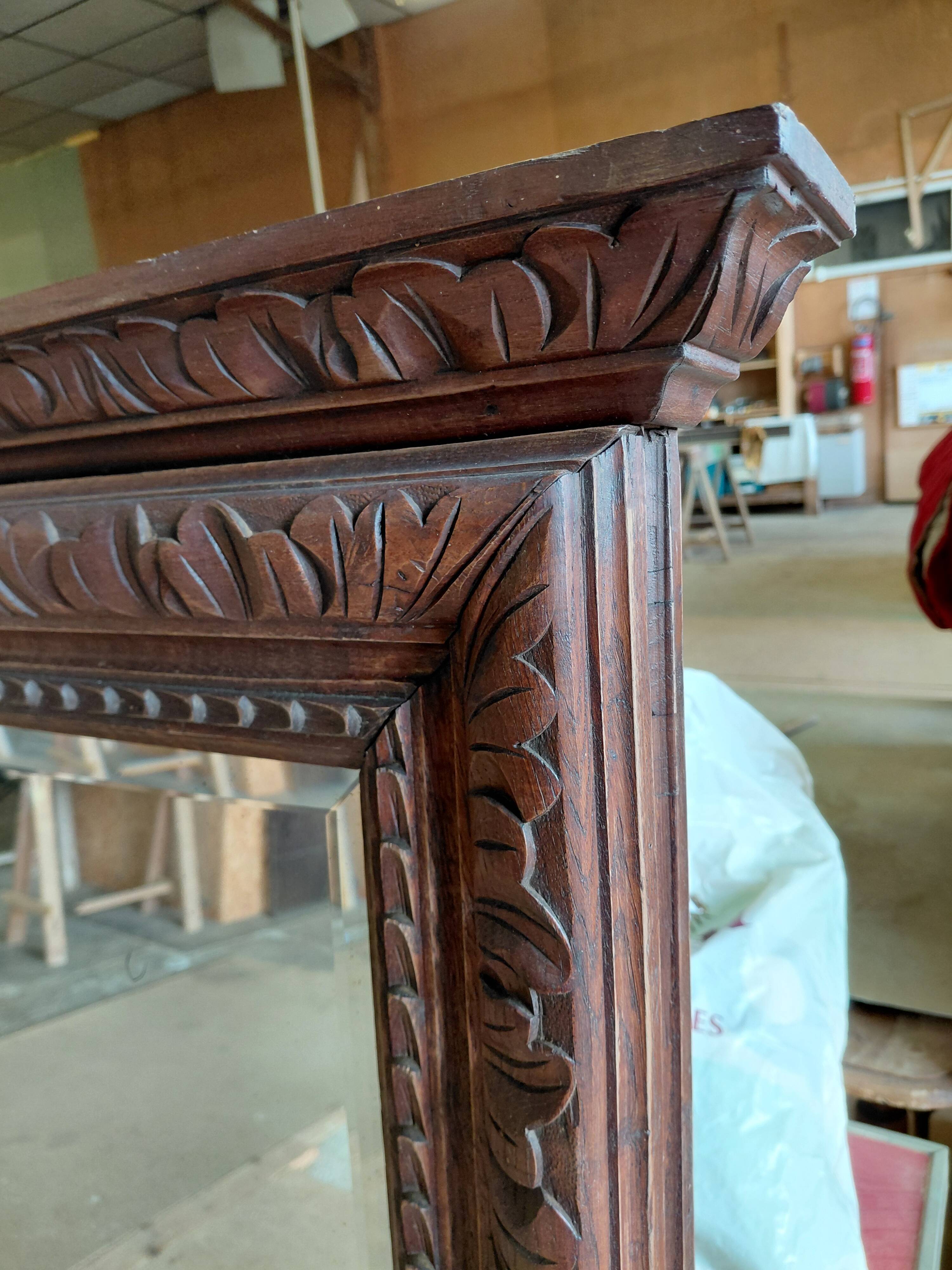 Large bevelled mirror with a carved wooden frame