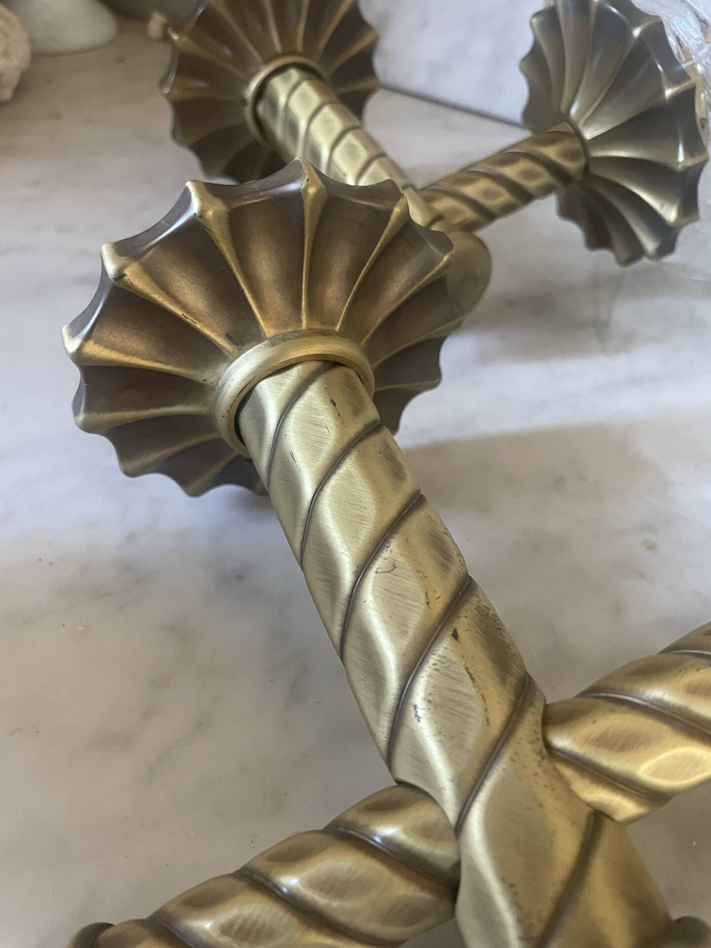 Pair of neoclassical wall sconces in twisted brass and ribbed glass.